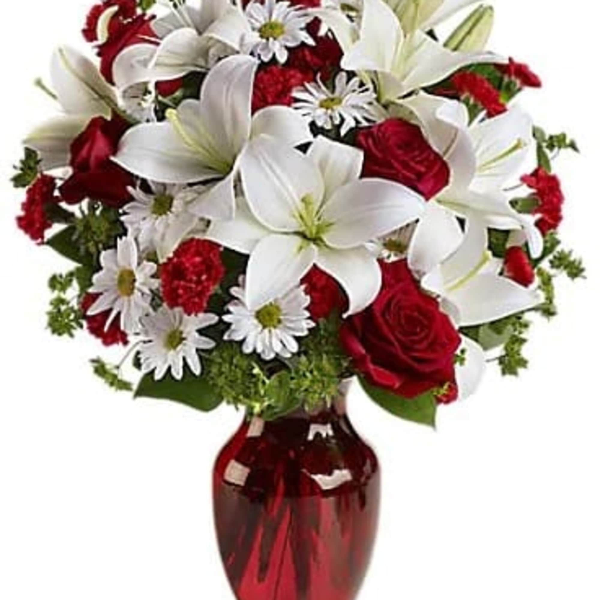 Bouquet of white lilies, red roses, and white daisies in a red vase