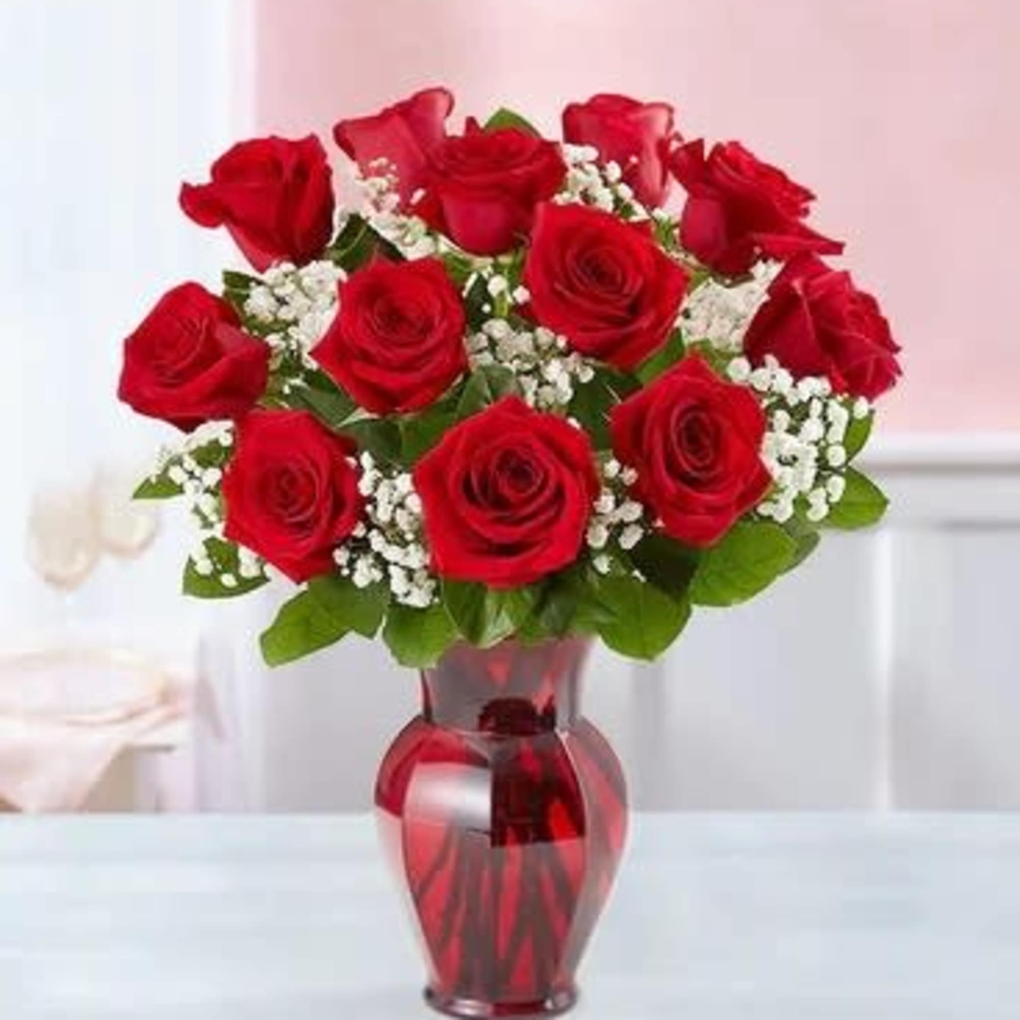 Red roses arranged in a red glass vase