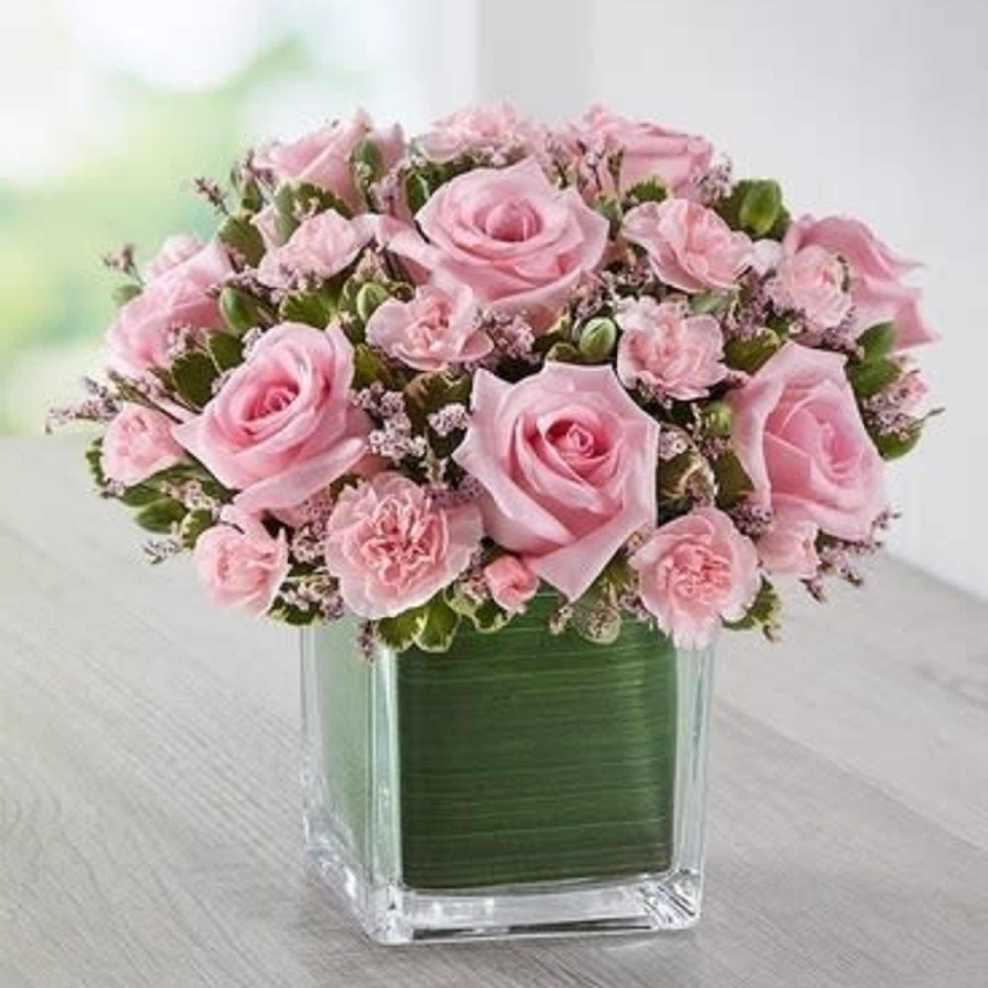 Pink roses and carnations arranged in a square glass vase, photo 2 of 3