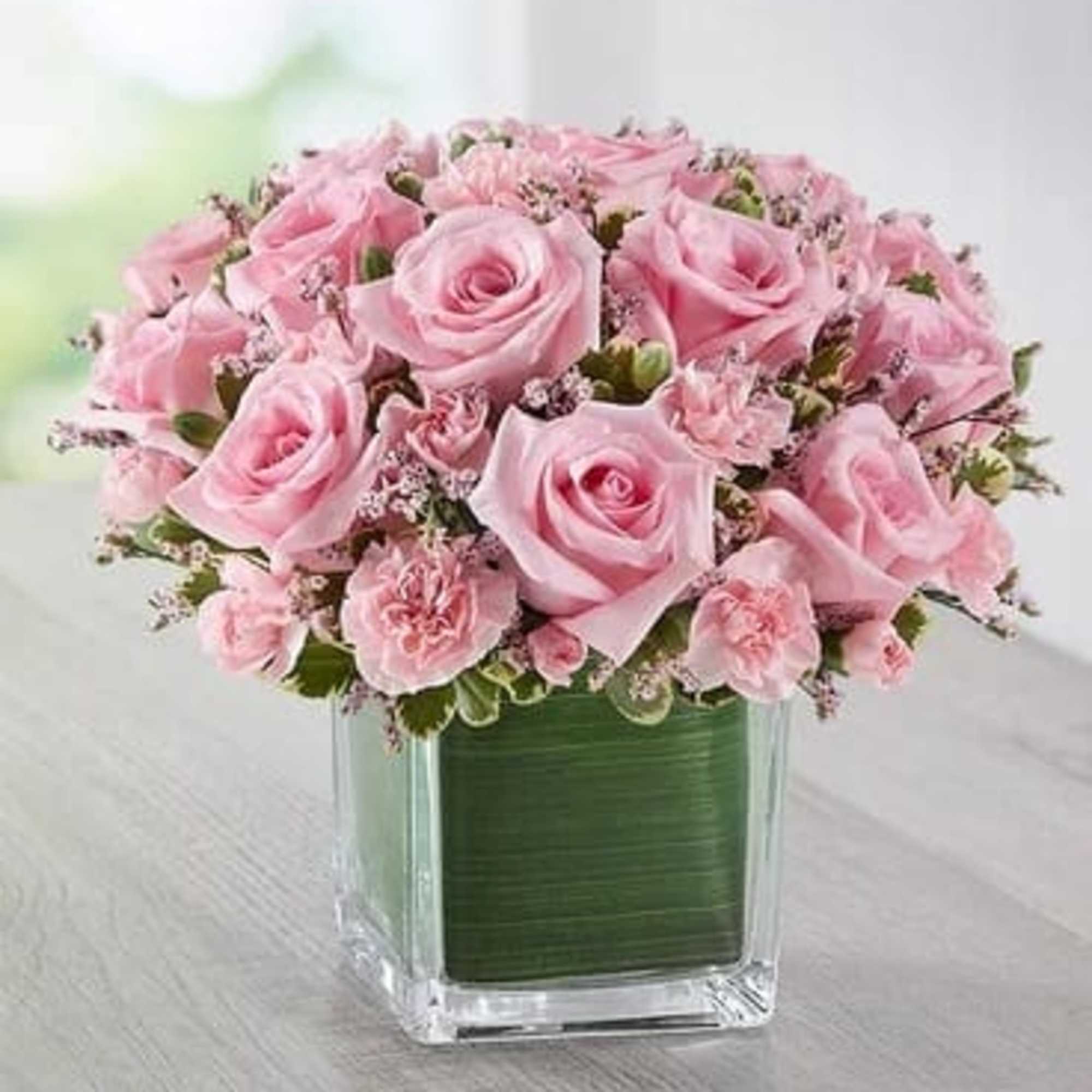 Pink roses arranged in a square glass vase