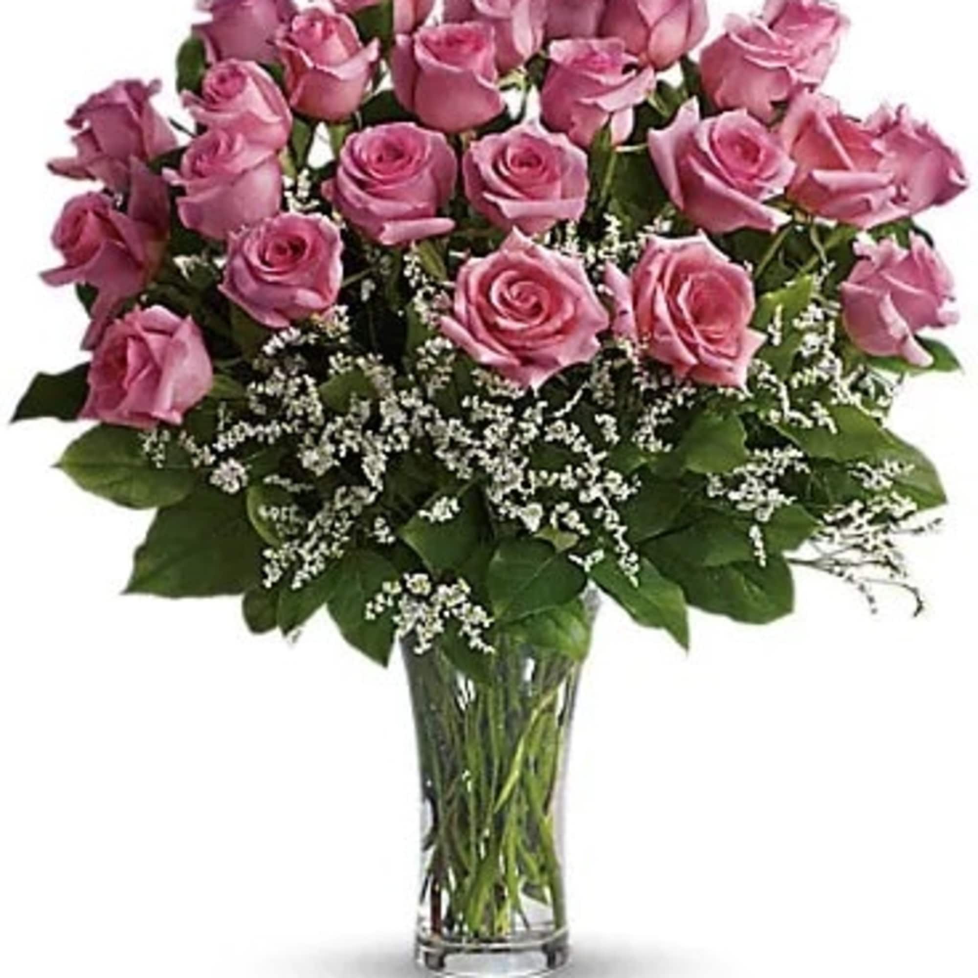 Pink roses arranged in a clear glass vase with white filler flowers