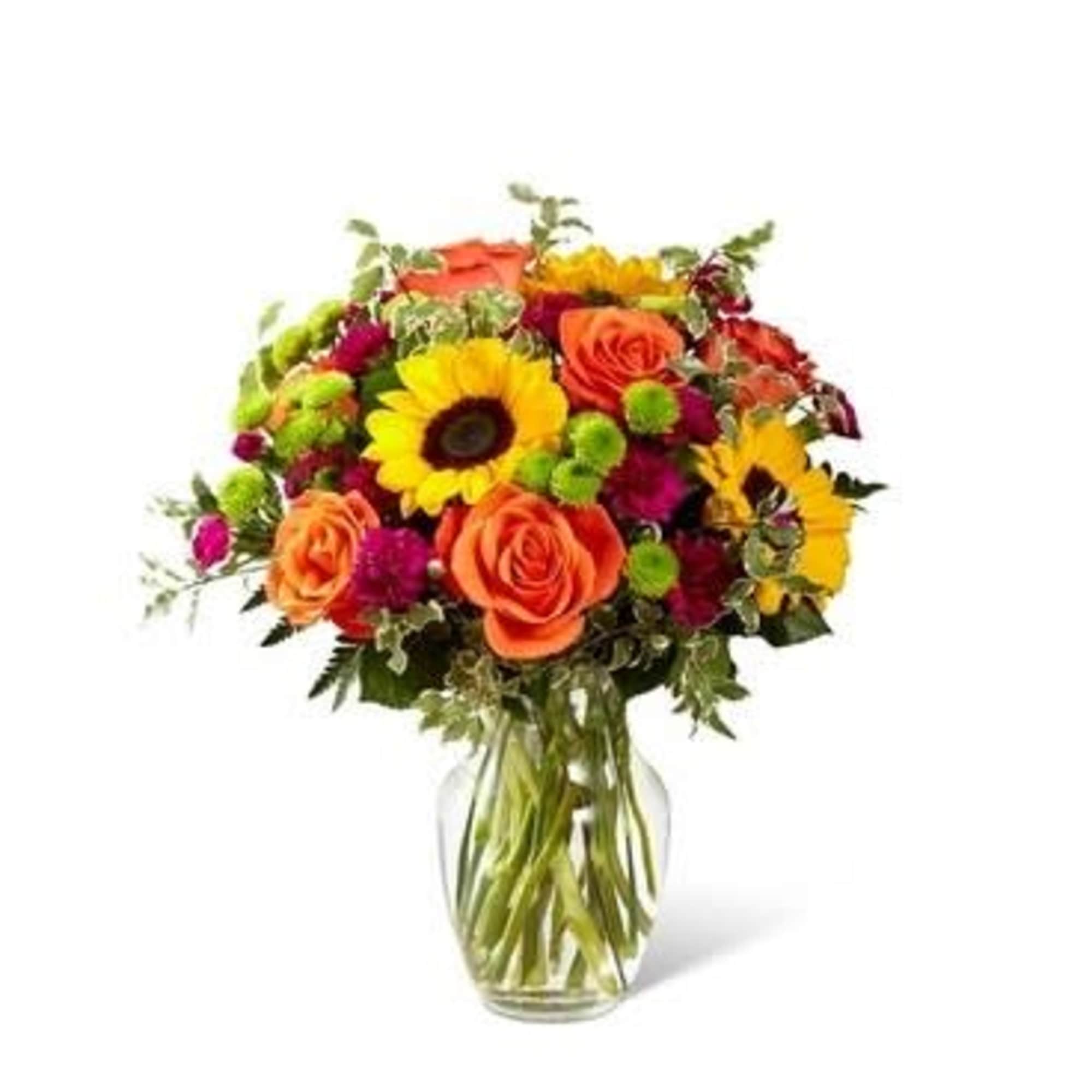 Bouquet of orange roses and yellow sunflowers in a glass vase