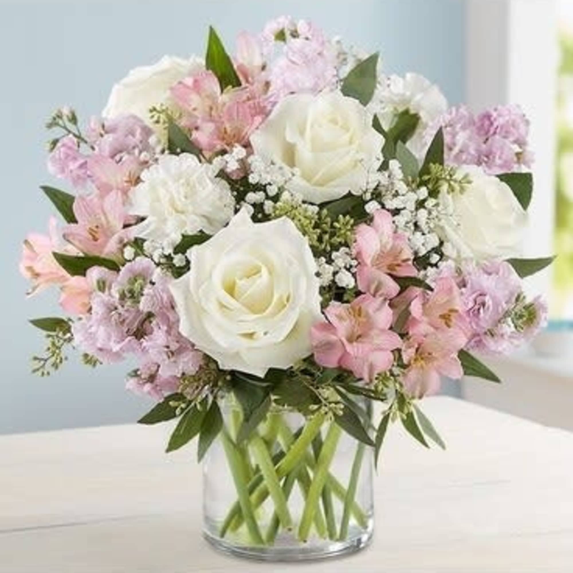 Bouquet of white roses and pink flowers in a clear glass vase