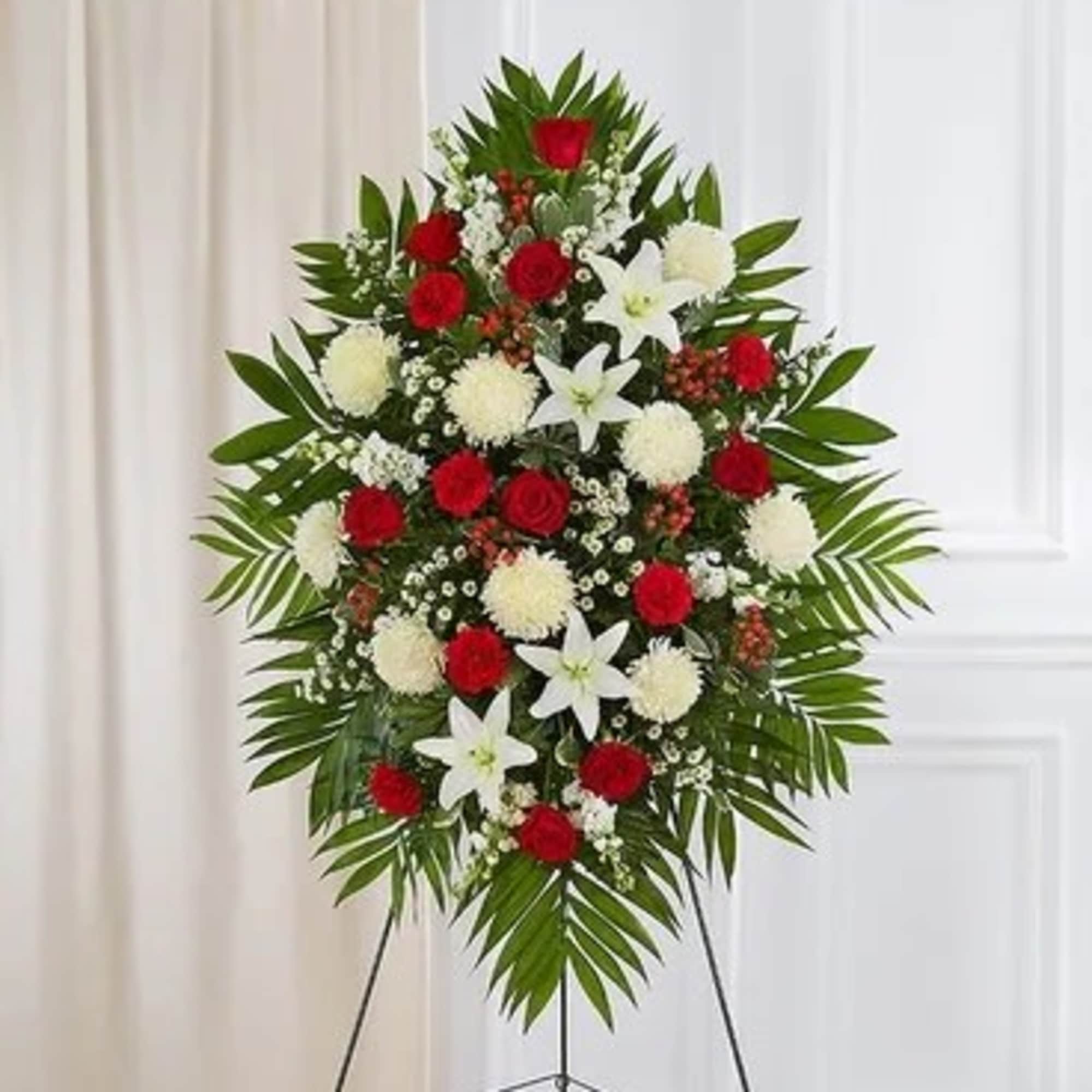 Standing floral spray with red and white flowers on a tripod easel
