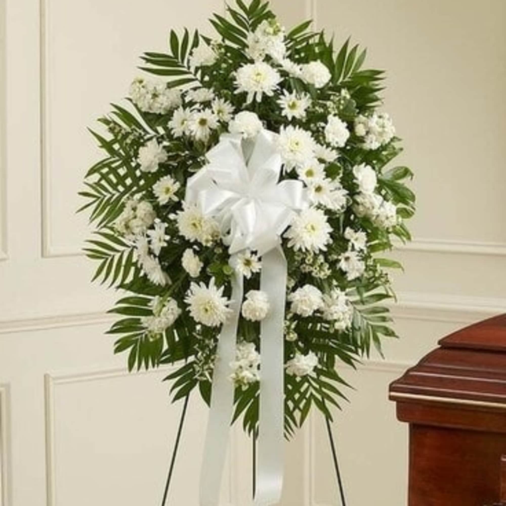 White funeral wreath with ribbon on a stand