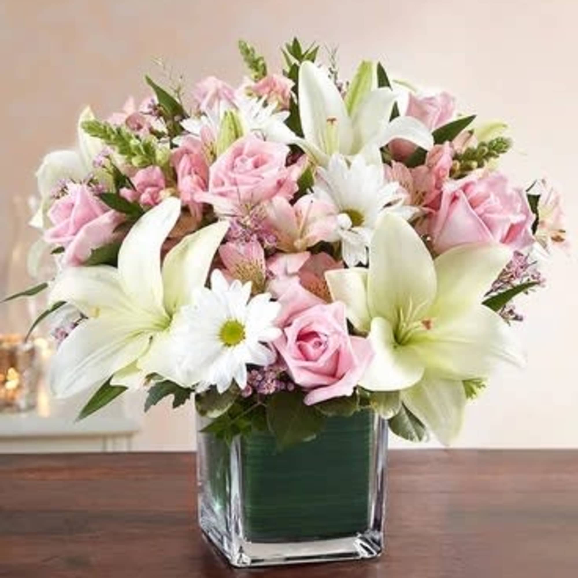Pink roses and white lilies arranged in a clear glass vase