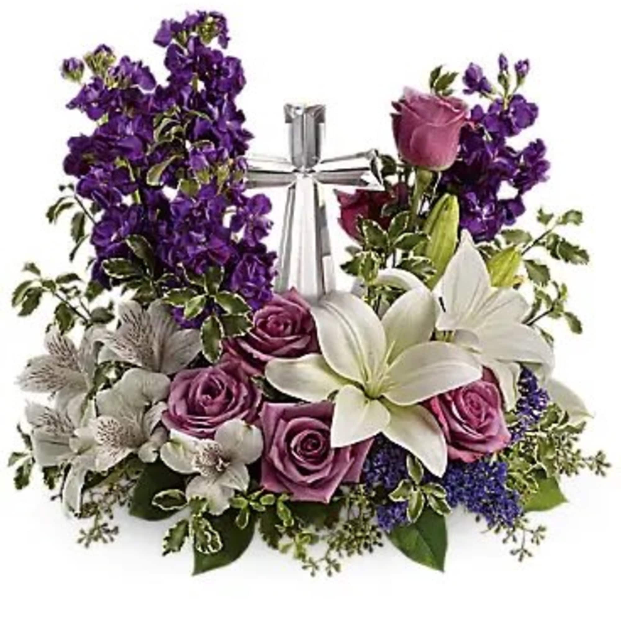 Purple and pink floral arrangement with white lilies and a silver ribbon centerpiece