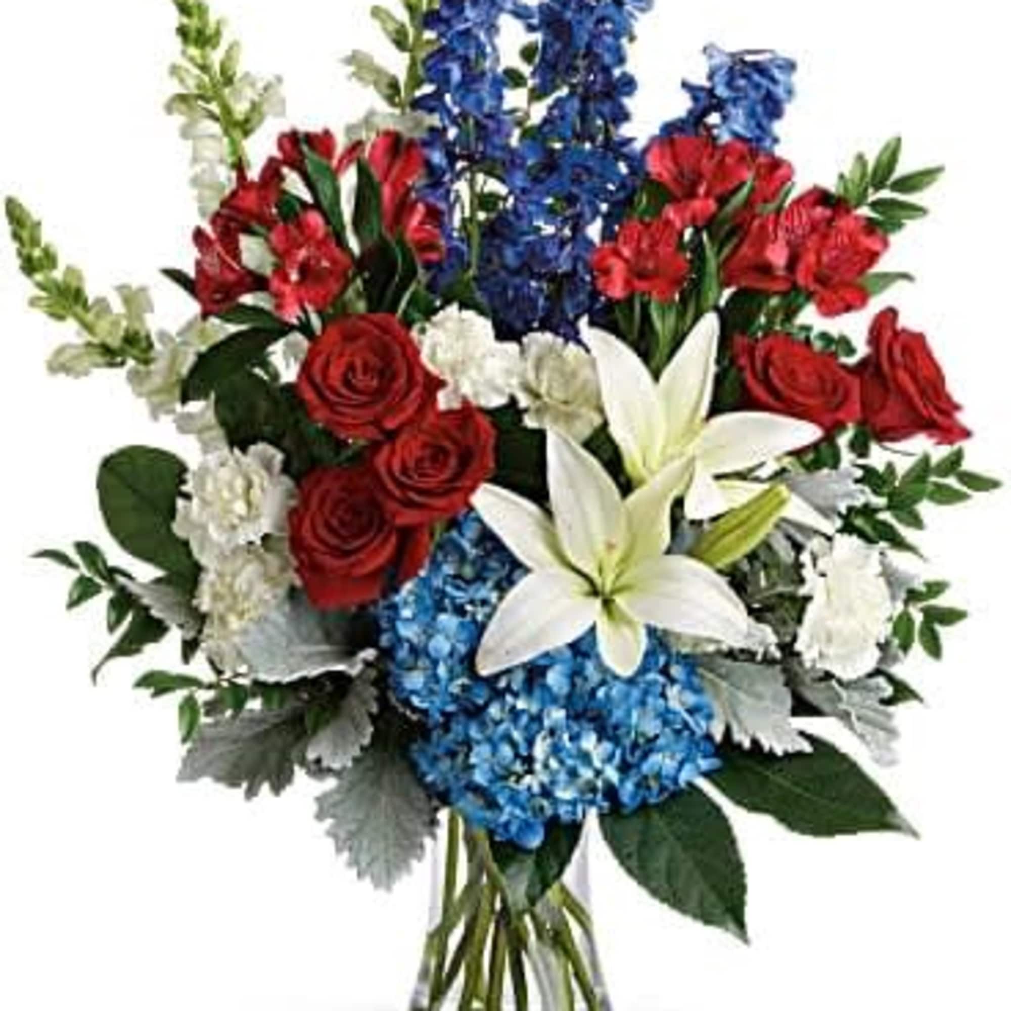 Bouquet of red roses, white lilies, and blue flowers in a clear vase