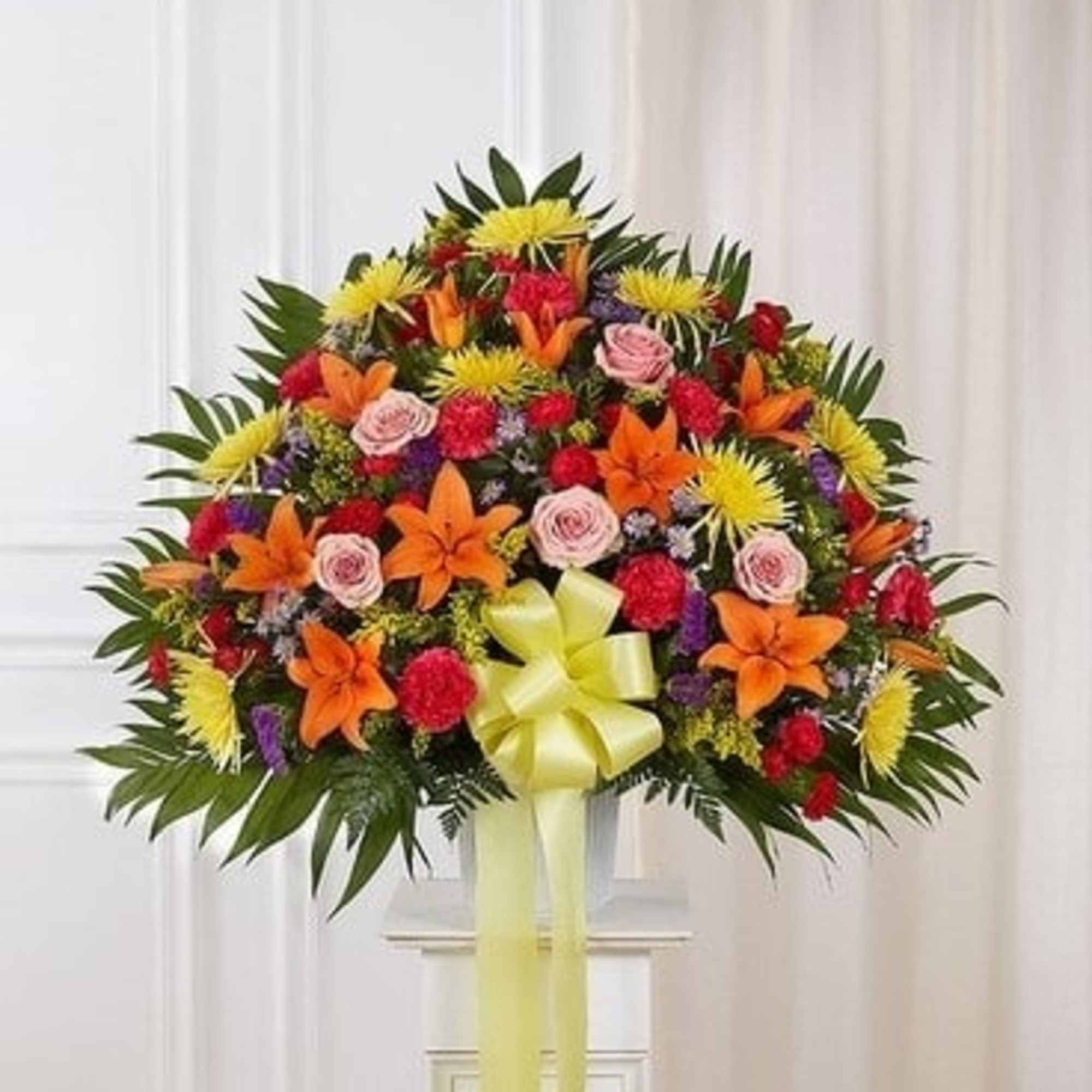 Large standing floral spray with orange, yellow, pink, and red blooms