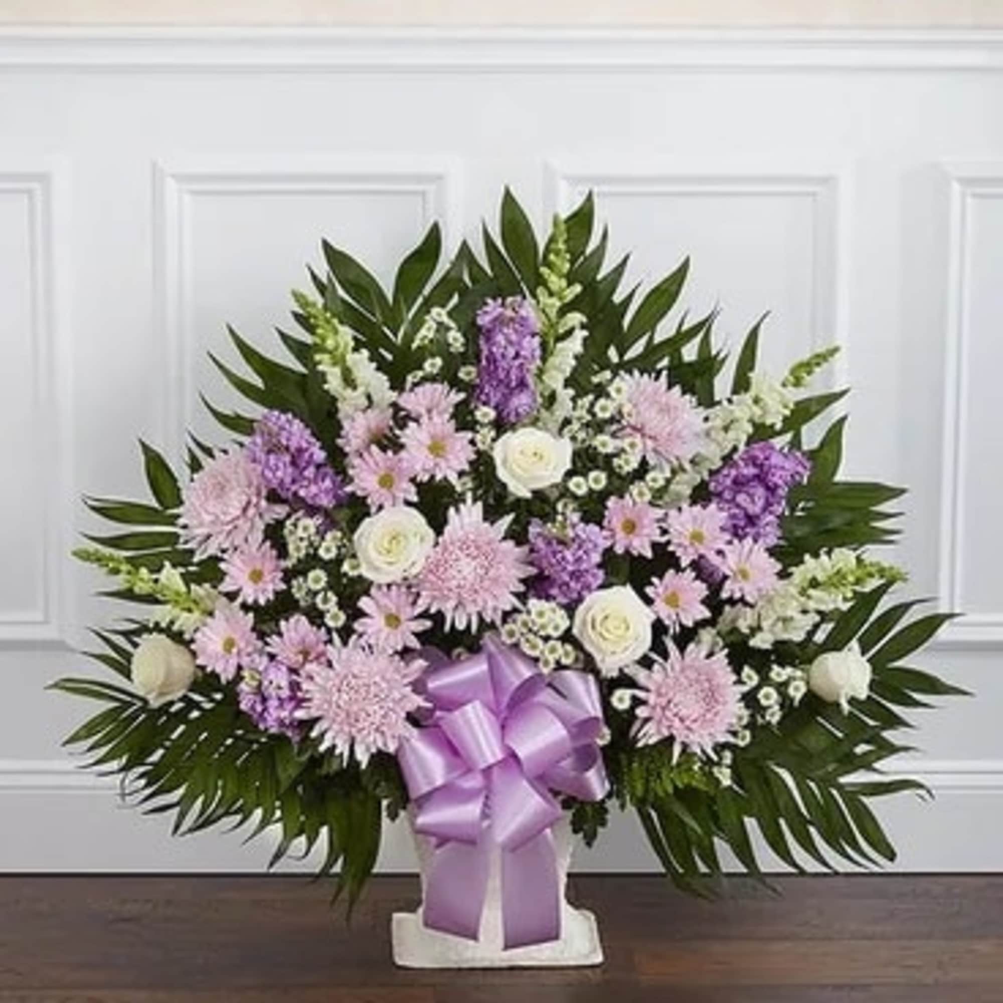 Lavender and white floral spray with a purple ribbon on a stand