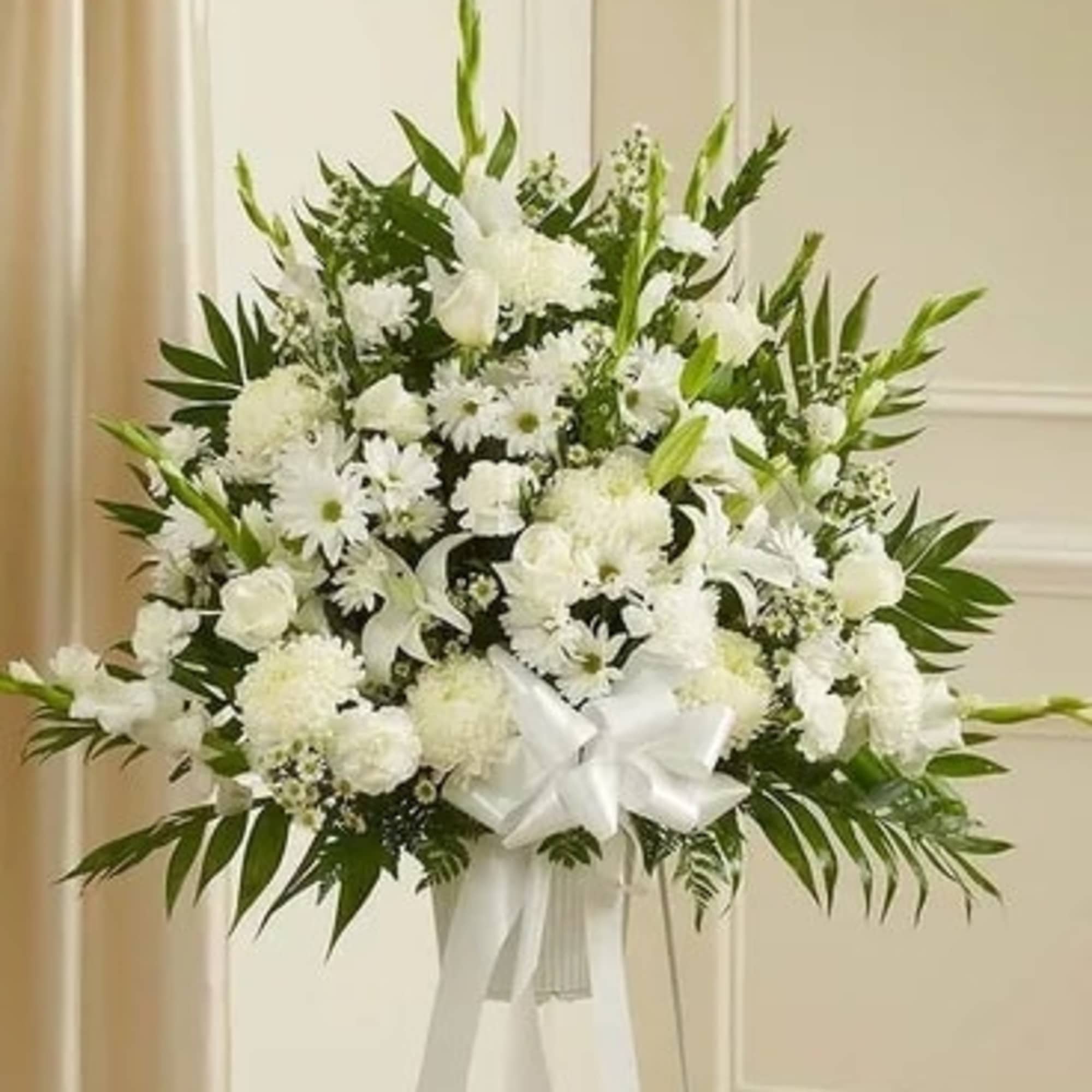 White funeral spray with lilies and daisies on a stand