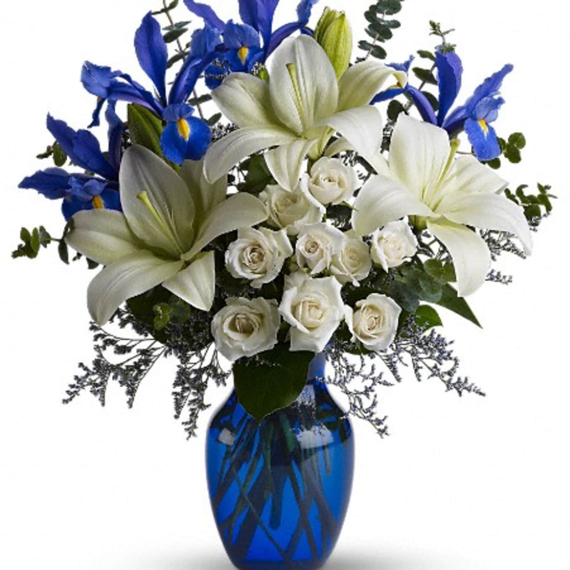 White lilies and roses with blue irises in a blue vase