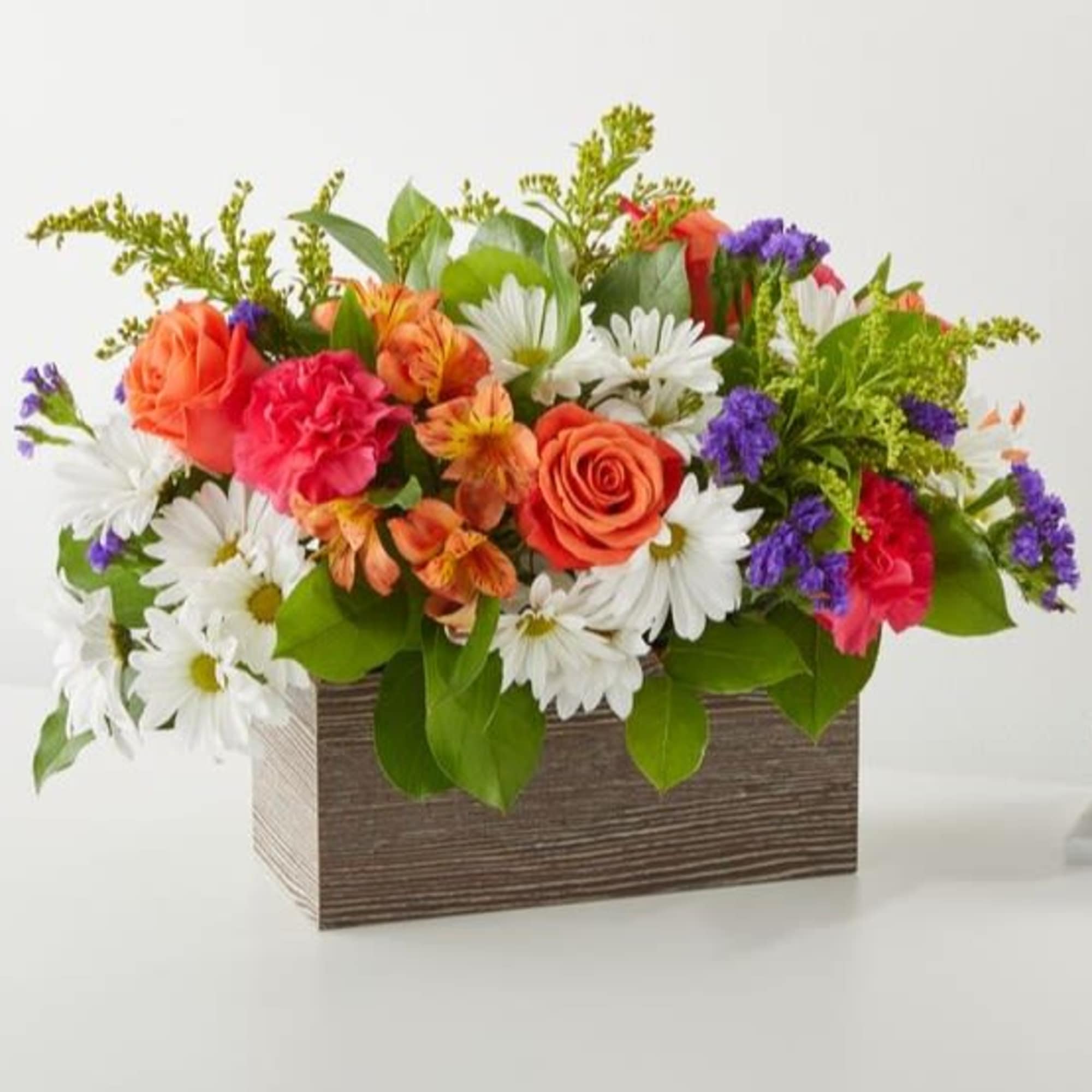 Mixed bouquet in a rectangular wooden box with orange, pink, white, and purple flowers