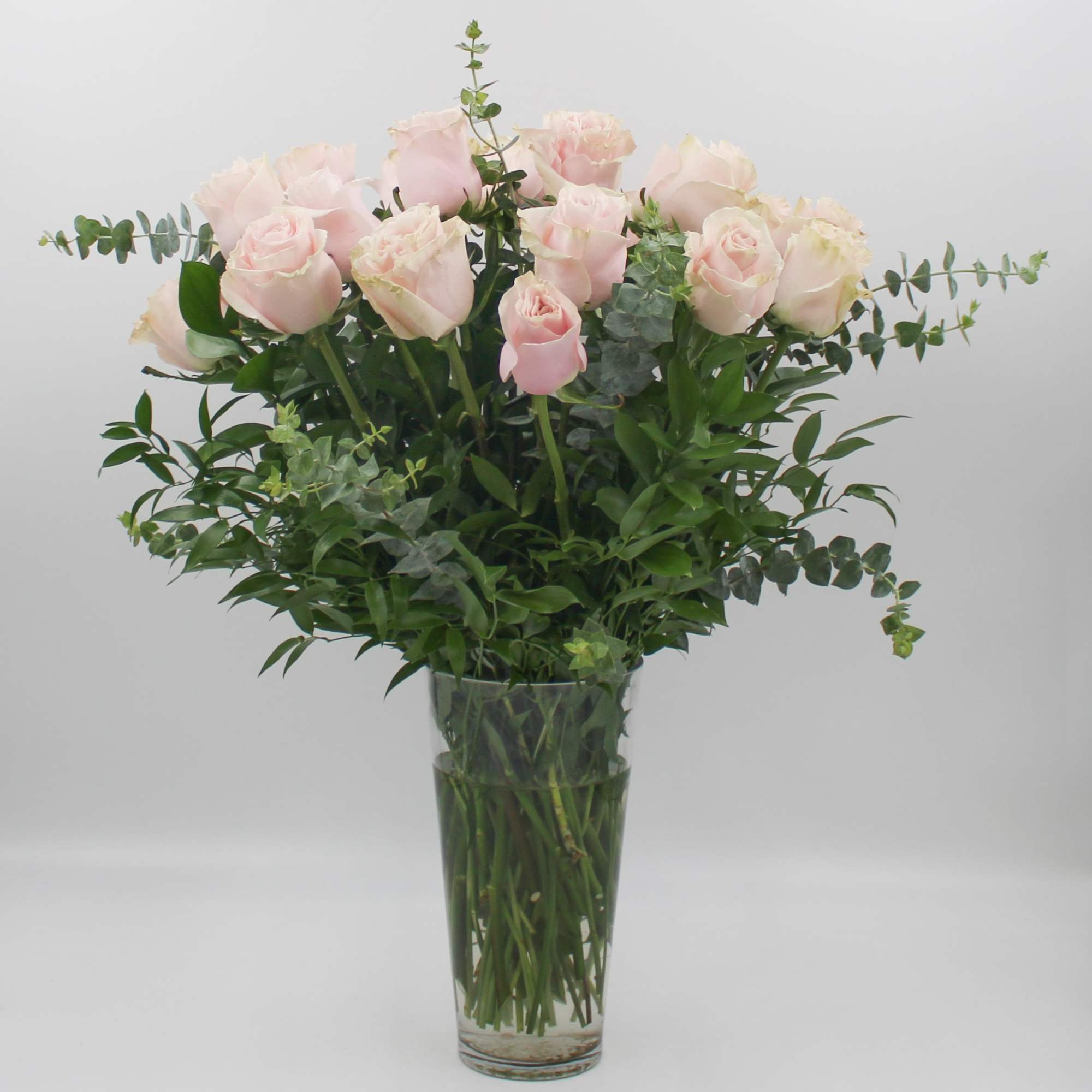 Bouquet of pale pink roses in a clear glass vase