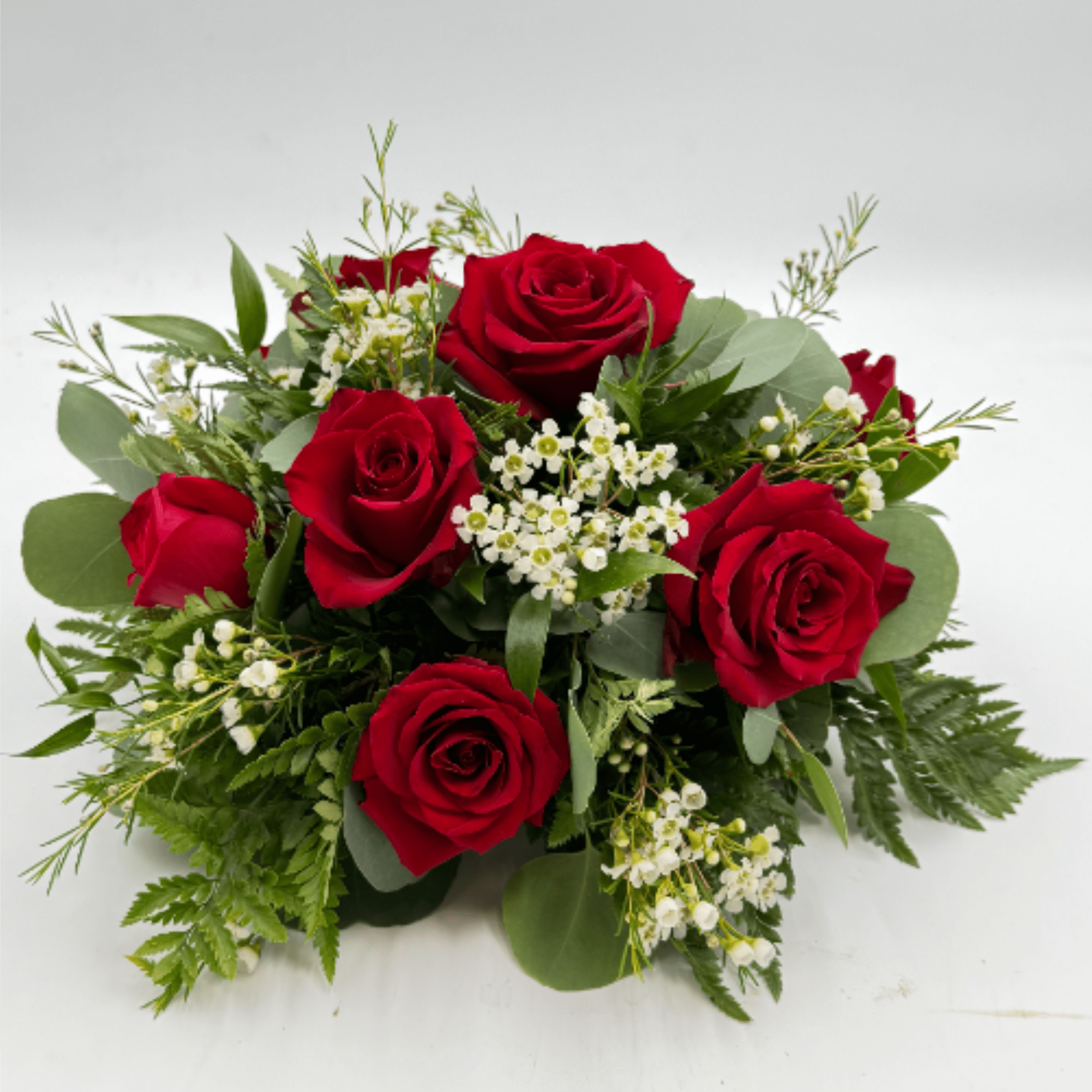 Deep clusters of deep red roses form the heart of this low