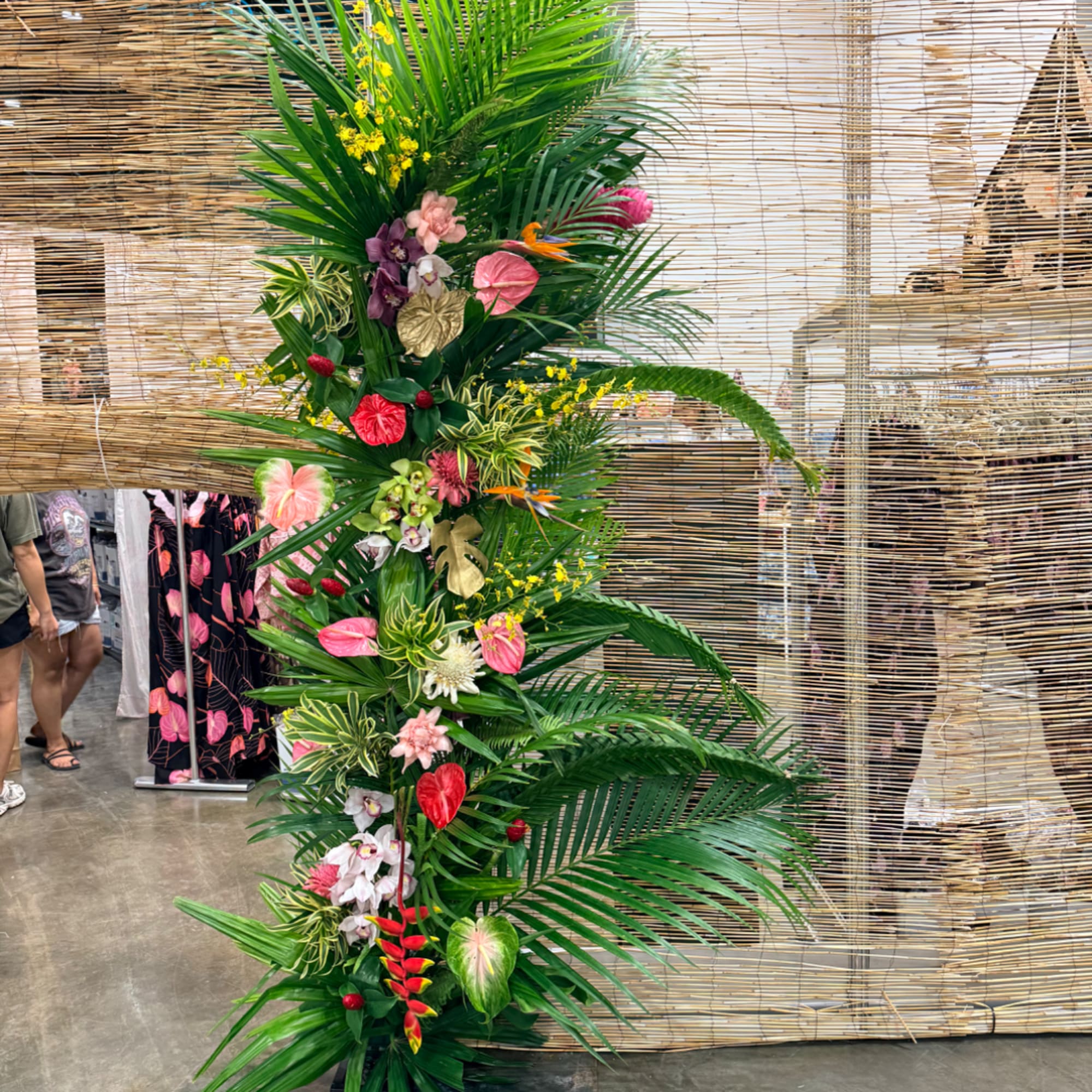 Tall tropical floral arrangement with pink, red, purple, and yellow blooms