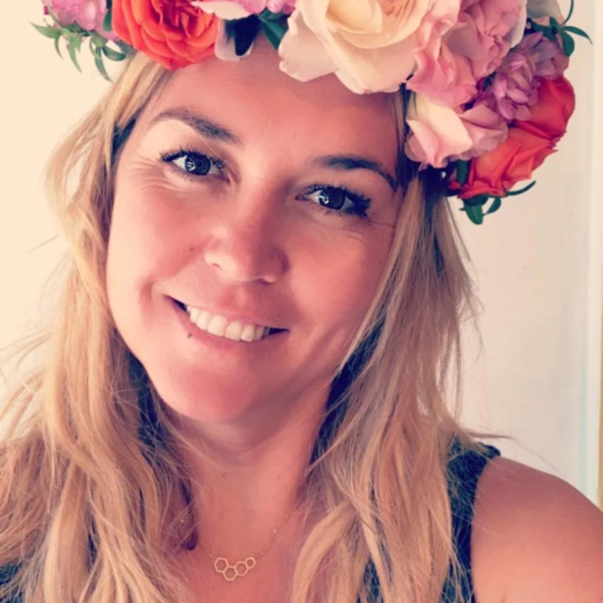 Woman wearing a flower crown of pink, white, and coral blooms