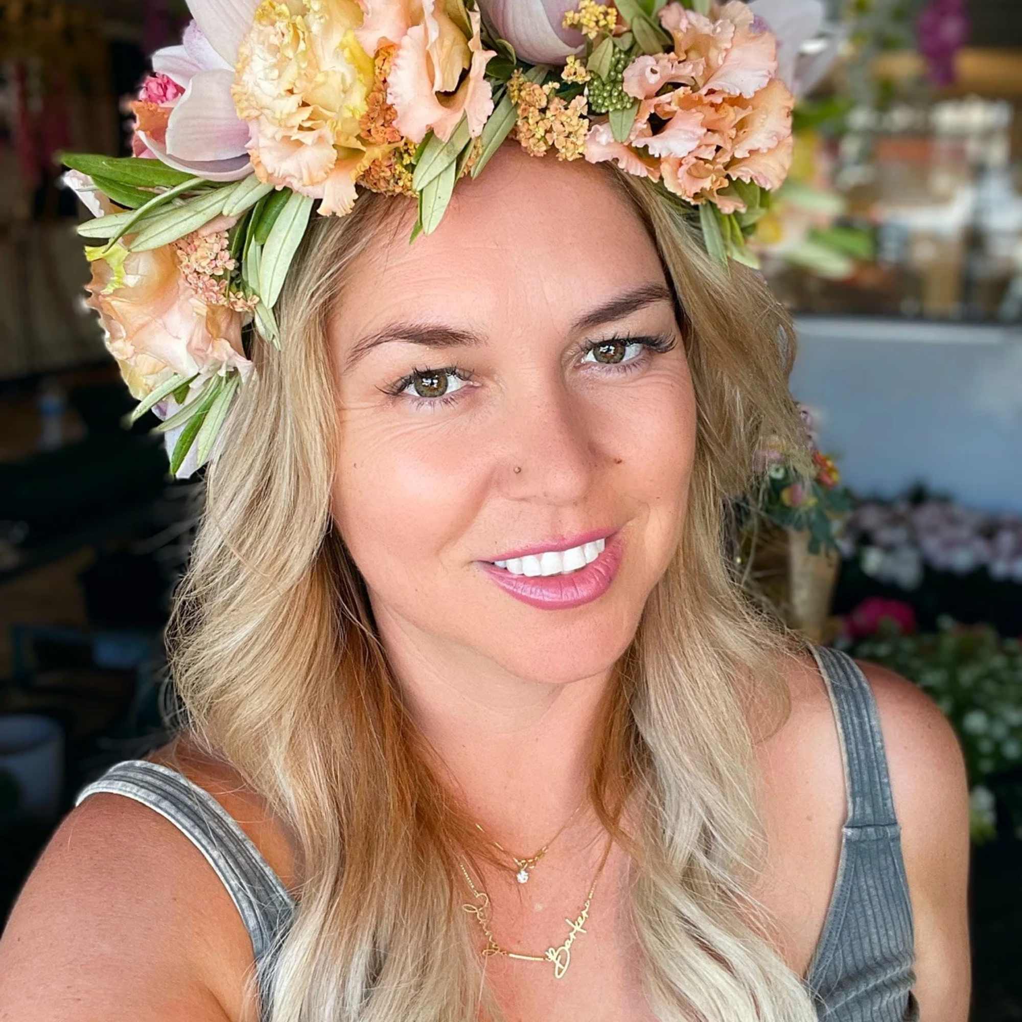 Woman wearing a pastel floral crown with peach and white flowers