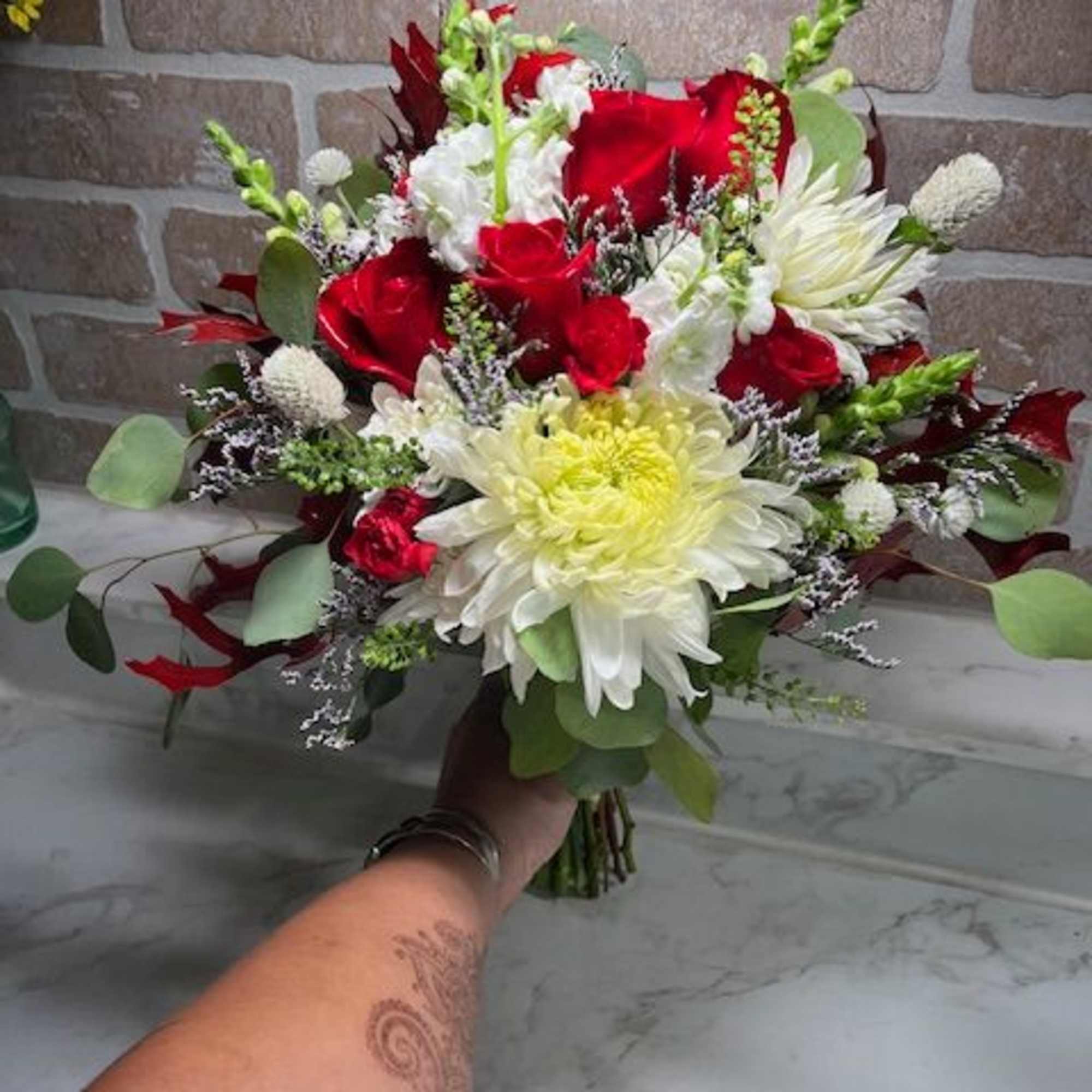 Bouquet of red roses and white chrysanthemums with greenery