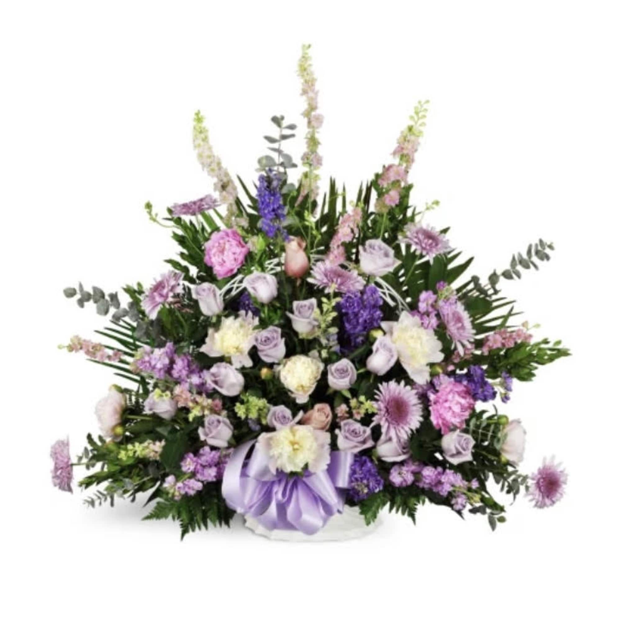Large lavender and pink floral arrangement with a purple ribbon bow