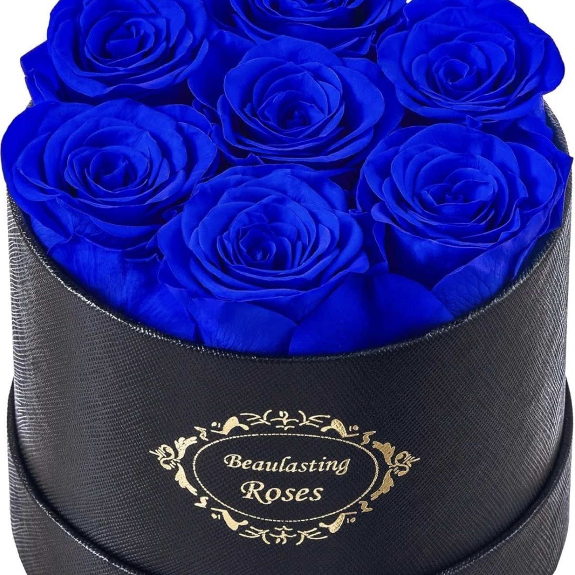 Round black hat box filled with vivid blue roses, viewed from above at a slight angle