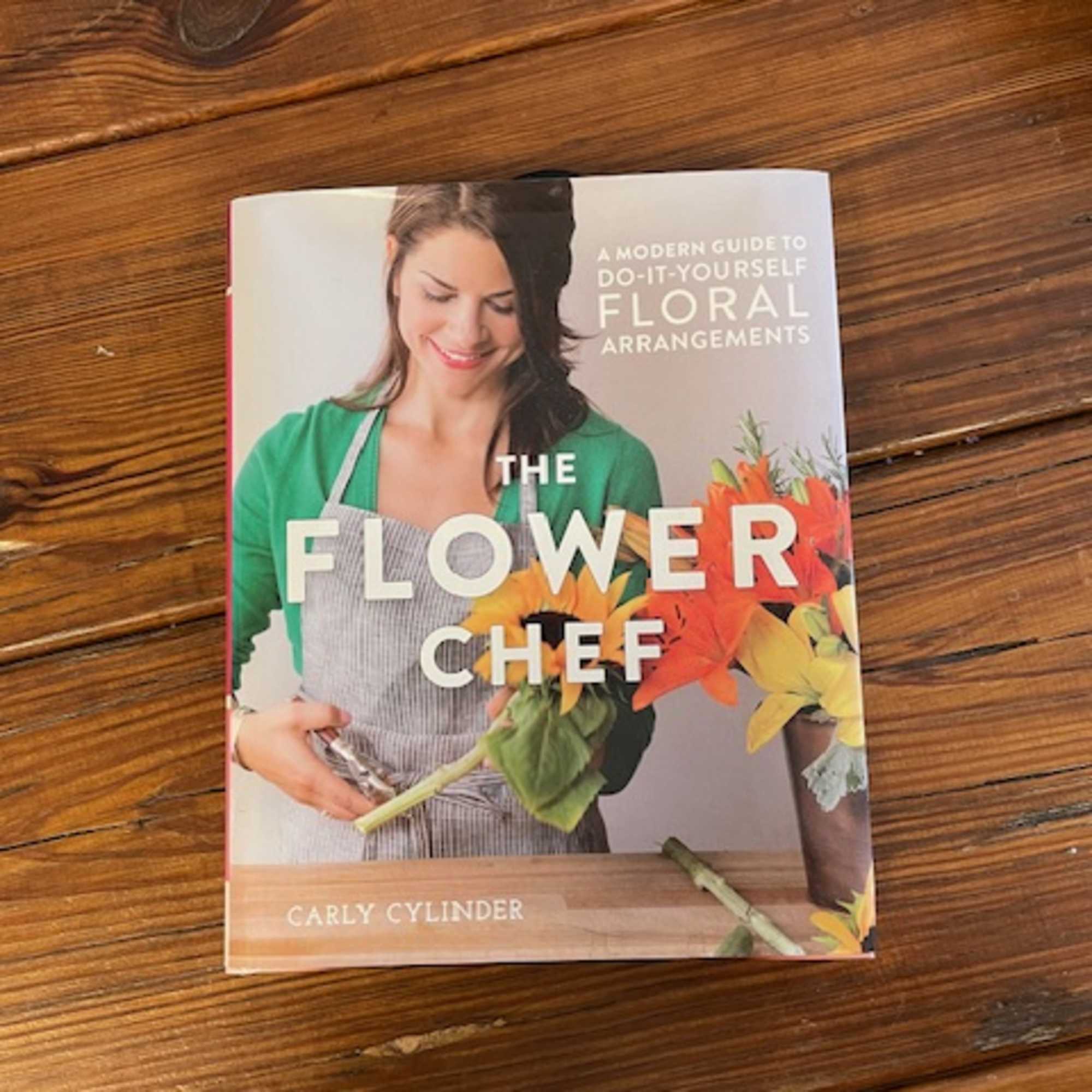 A floral arrangement guide book on a wooden table