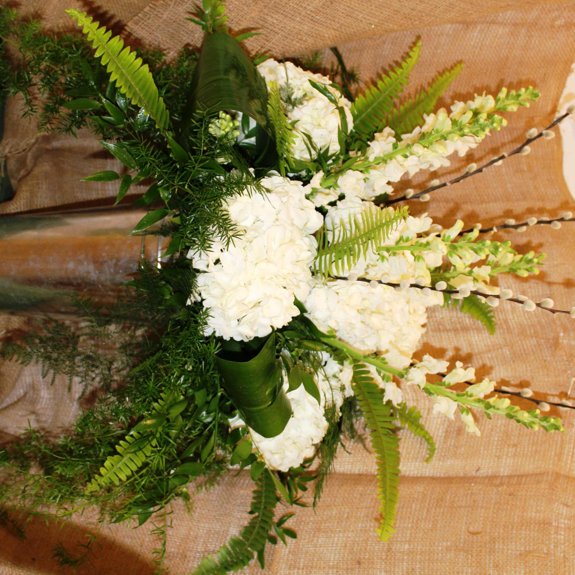 White floral arrangement in a tall glass vase with fern accents, photo 2 of 3