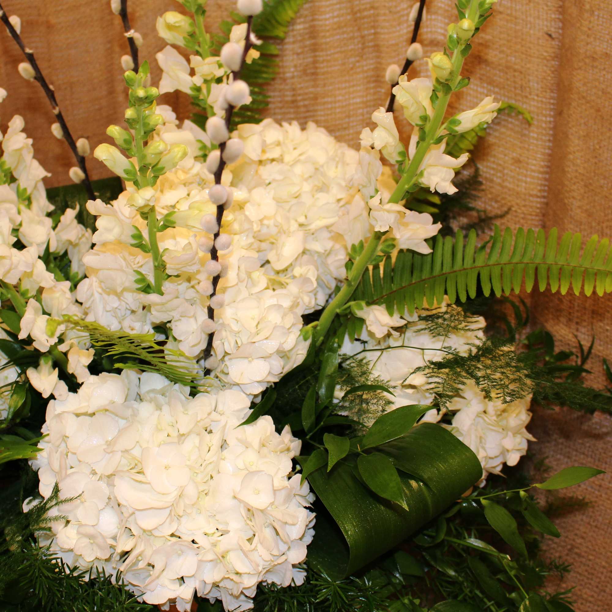 White floral arrangement with tall spikes and fern accents