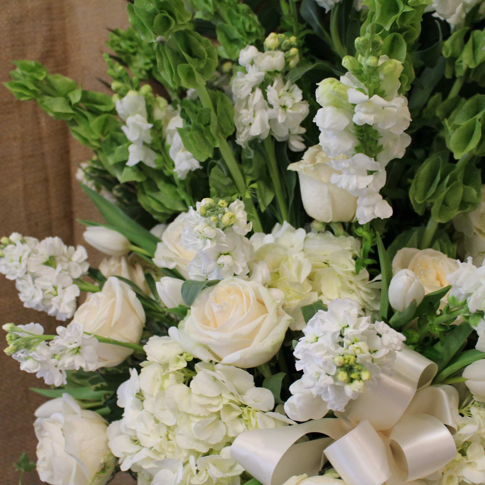 White roses and hydrangeas with green snapdragons and a satin ribbon