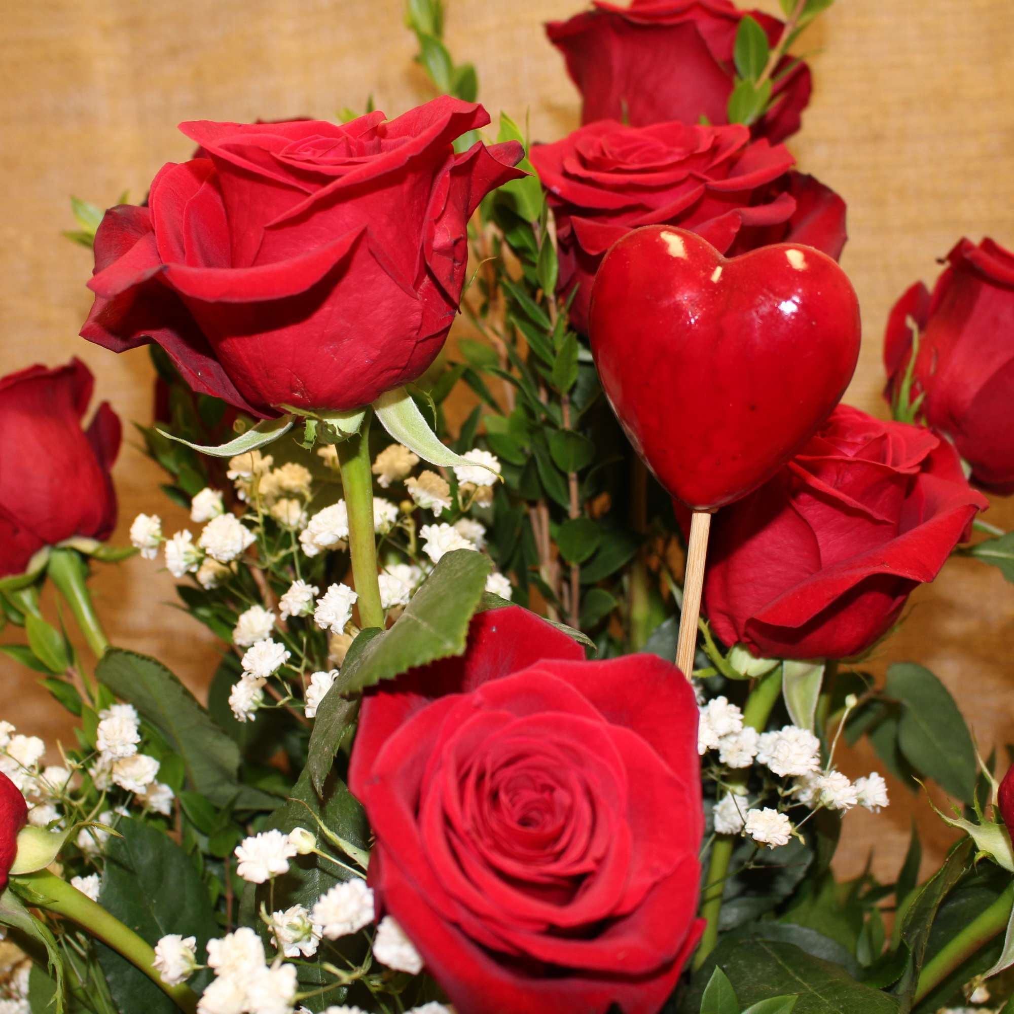 Red roses with baby's breath and a red heart pick