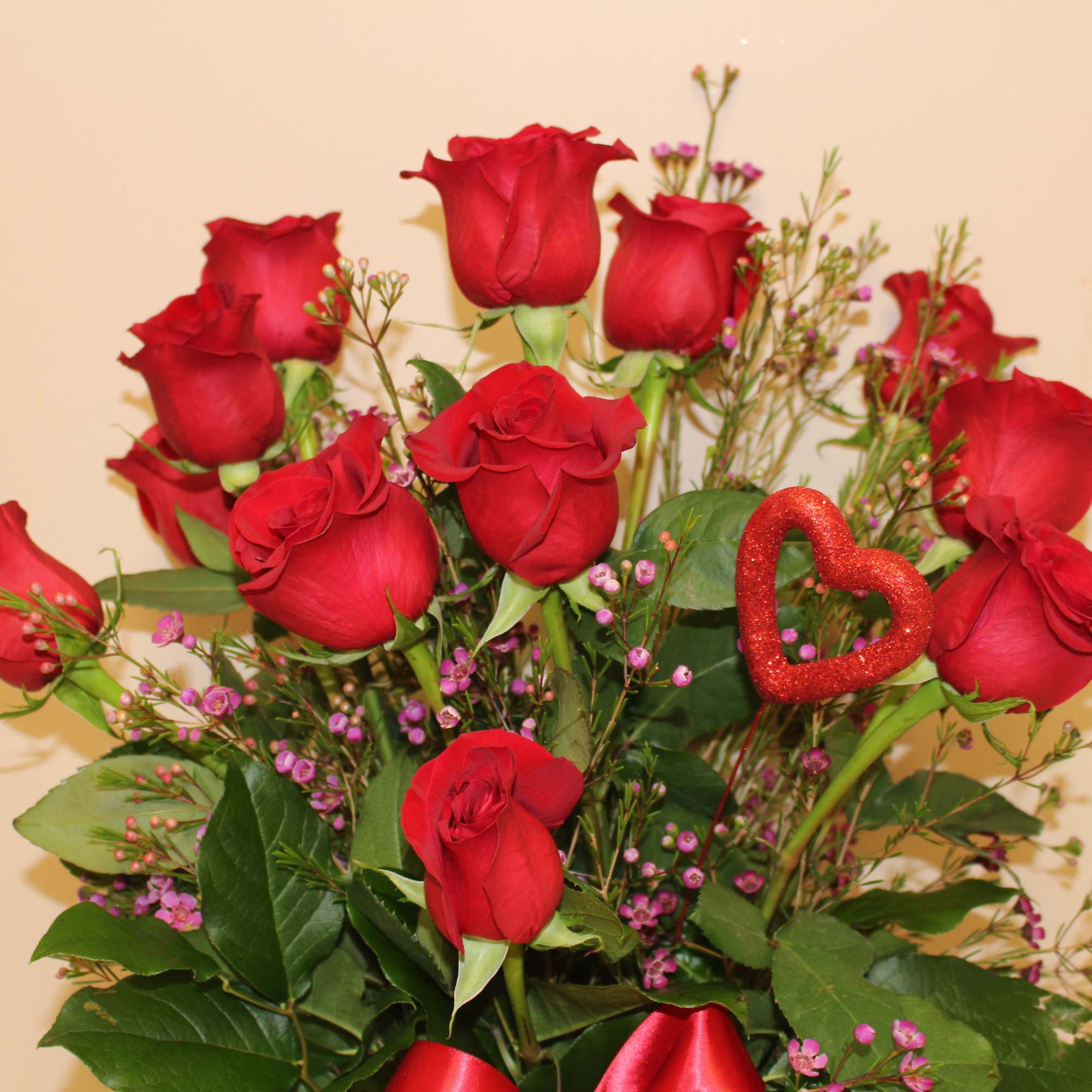 Bouquet of red roses with pink filler and a glitter heart pick