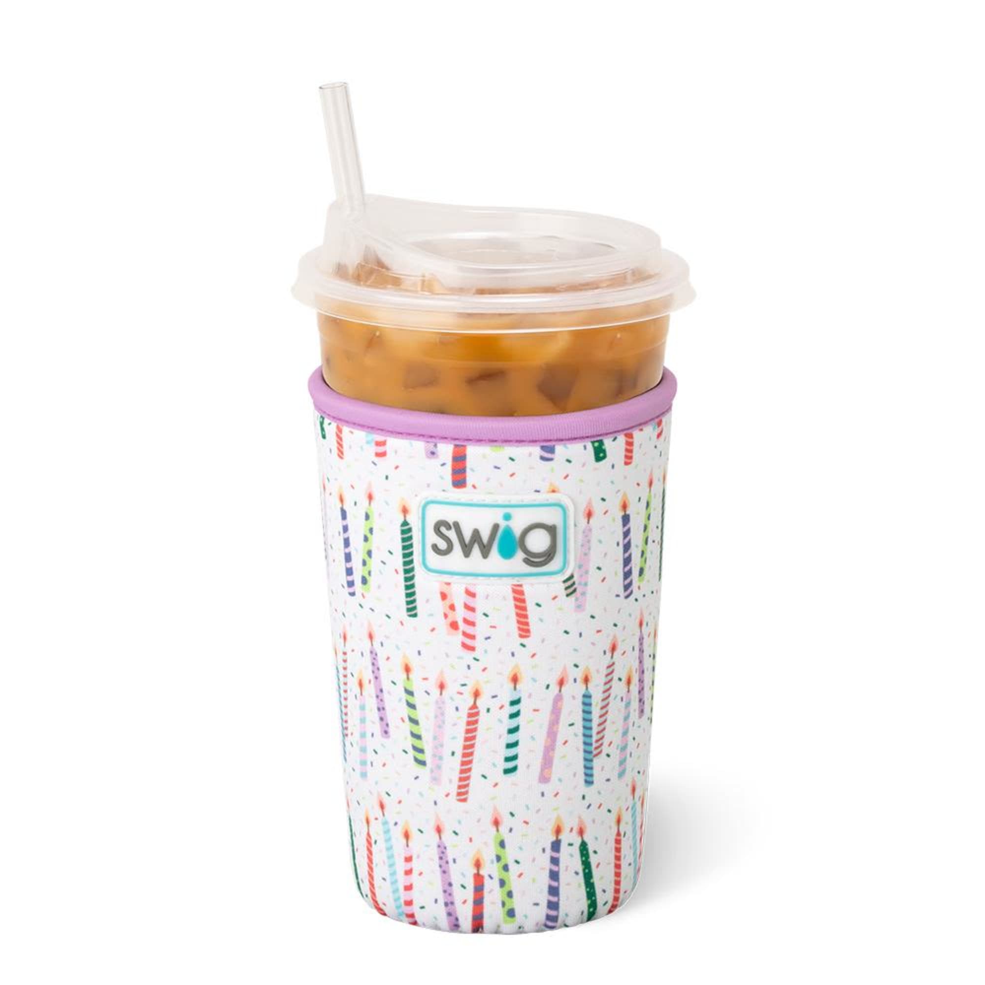 Iced drink in a clear plastic cup with a straw and candle-print sleeve