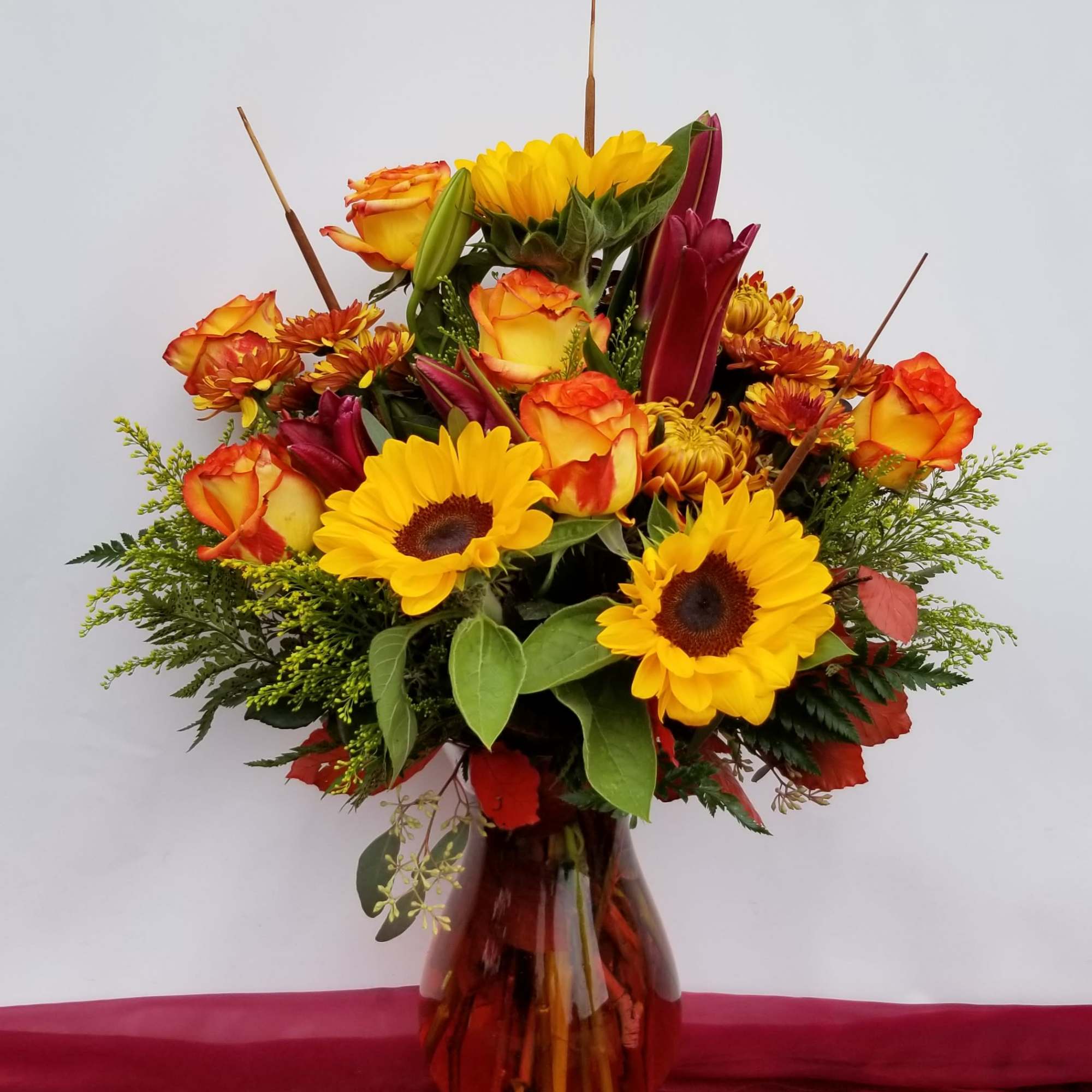 Sunflower and orange rose bouquet in a glass vase
