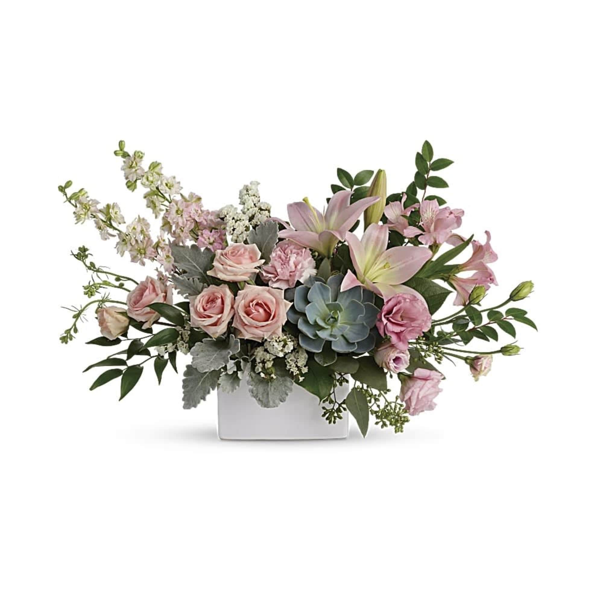 Pink roses and lilies arranged in a white square vase