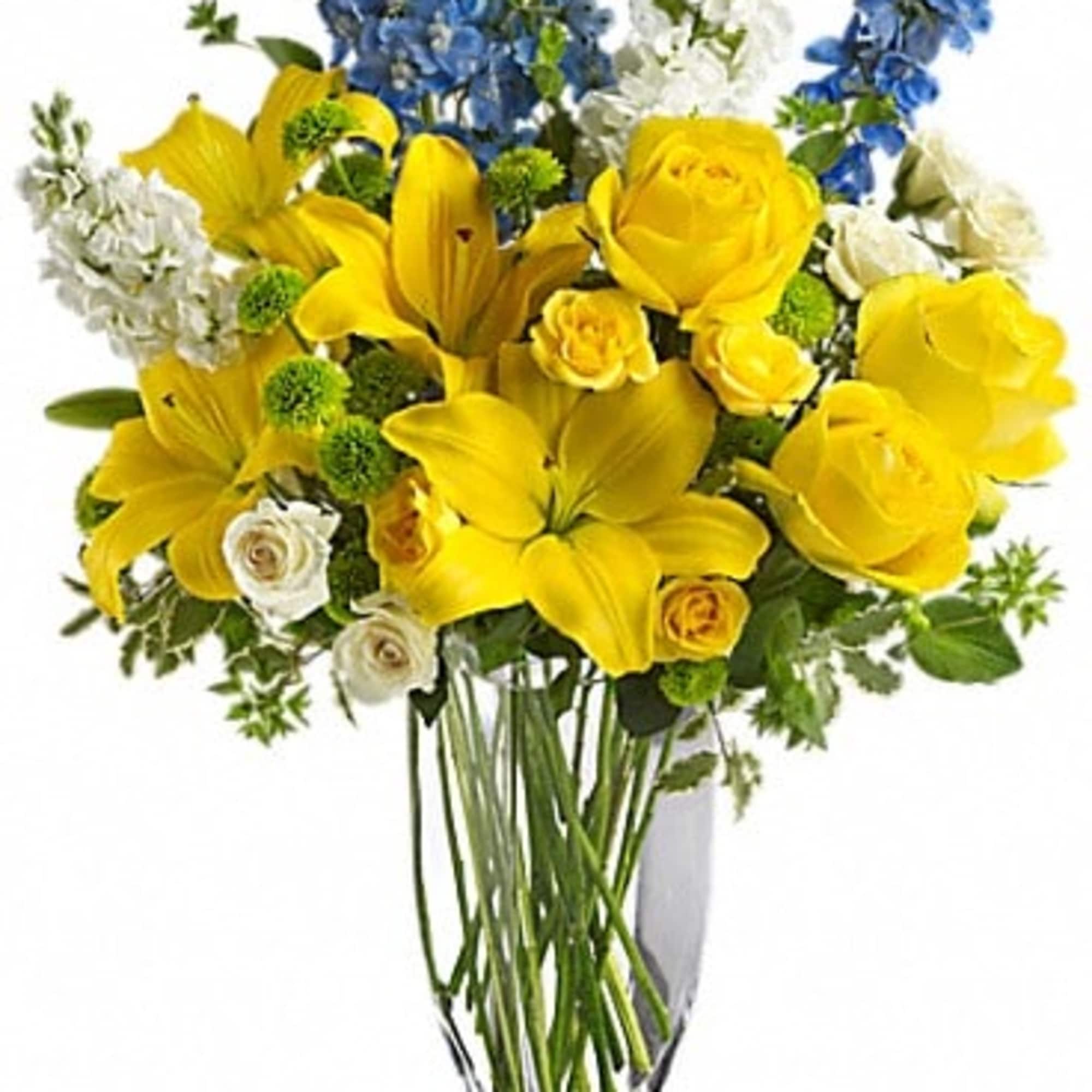 Yellow lilies and roses with blue and white flowers in a clear vase