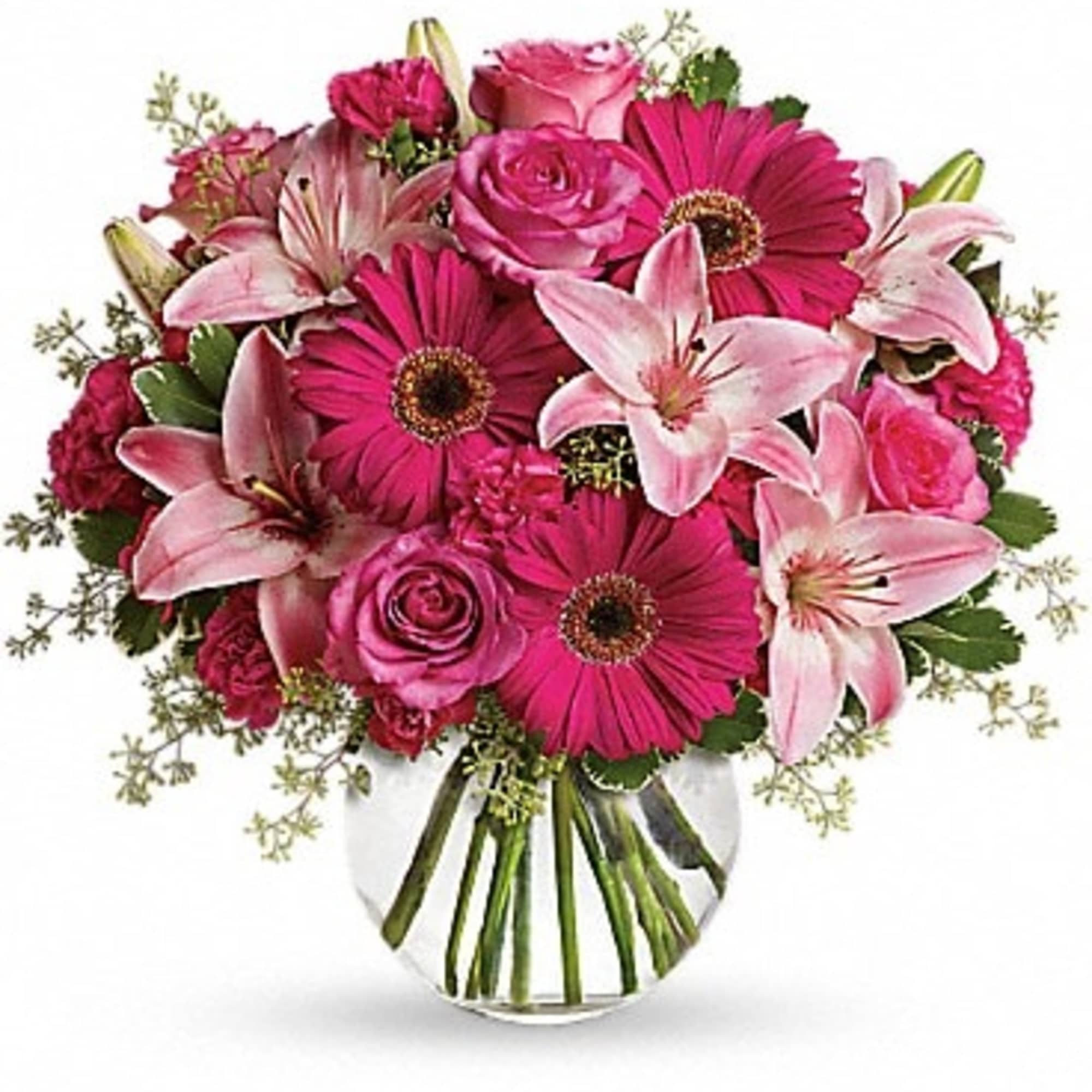 Pink roses, lilies, and gerbera daisies in a clear glass vase