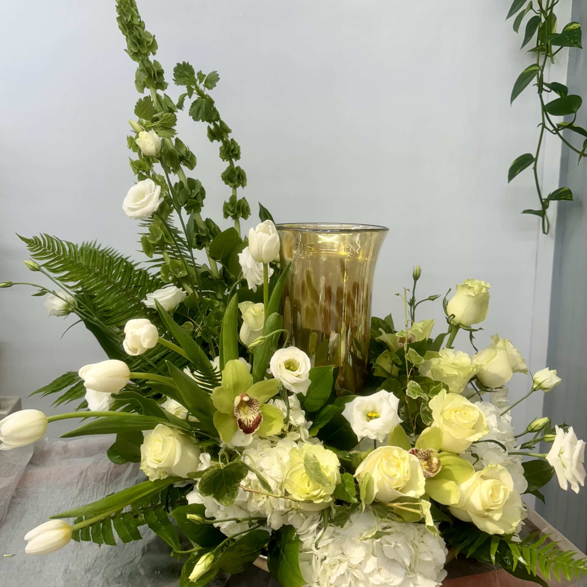 White and pale yellow floral arrangement with a gold vase centerpiece