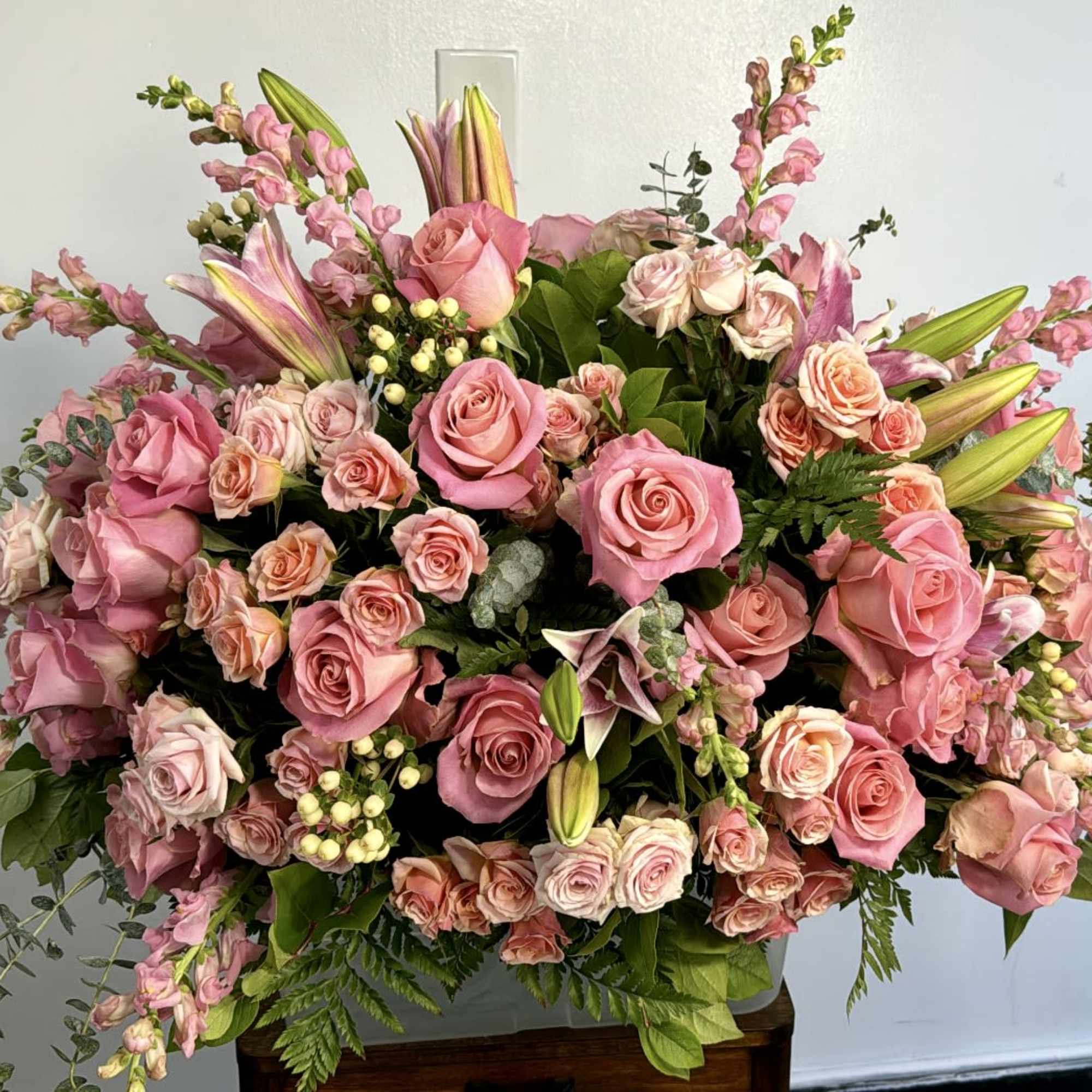 Large pink rose arrangement with lilies and snapdragons in a vase
