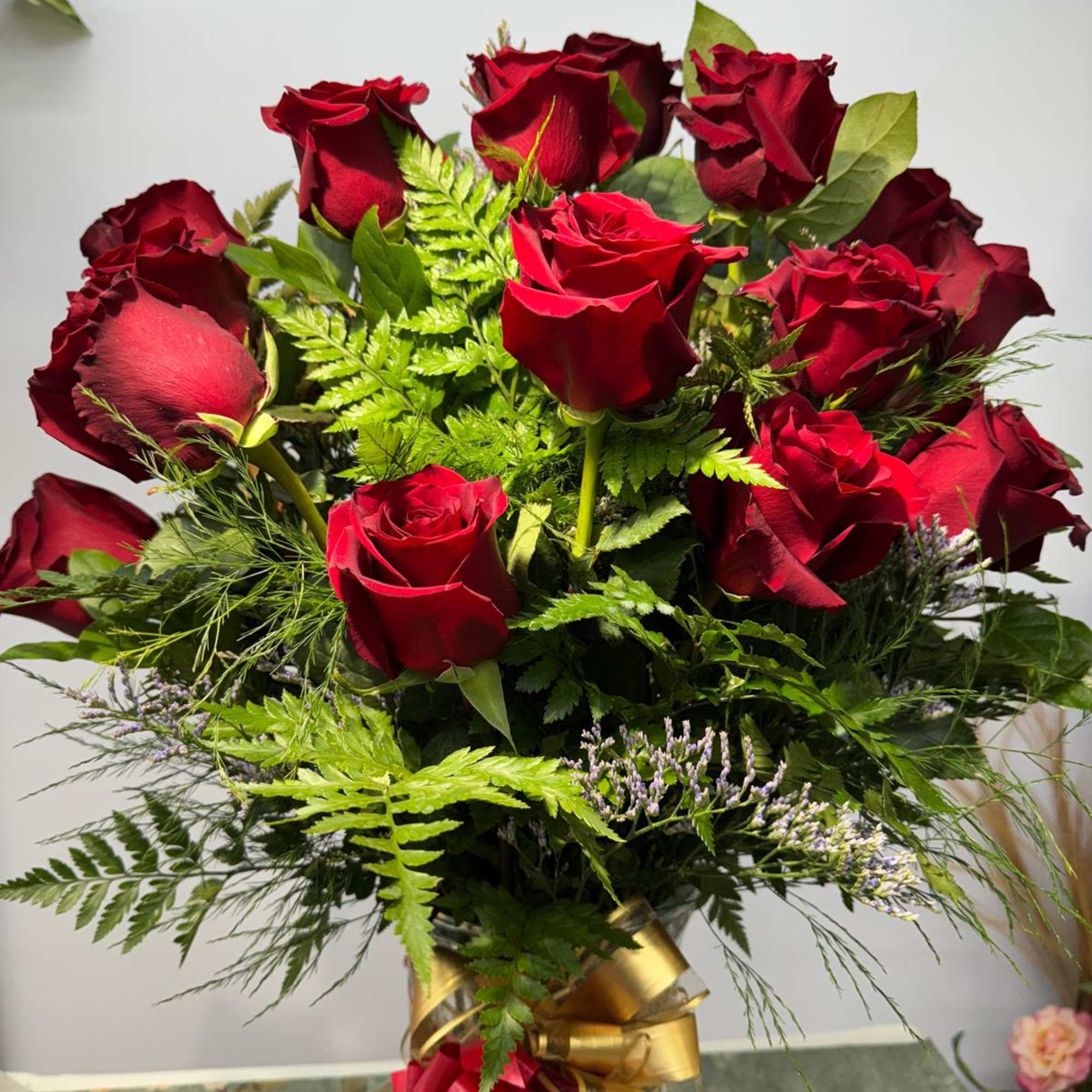 Bouquet of red roses with greenery in a clear vase