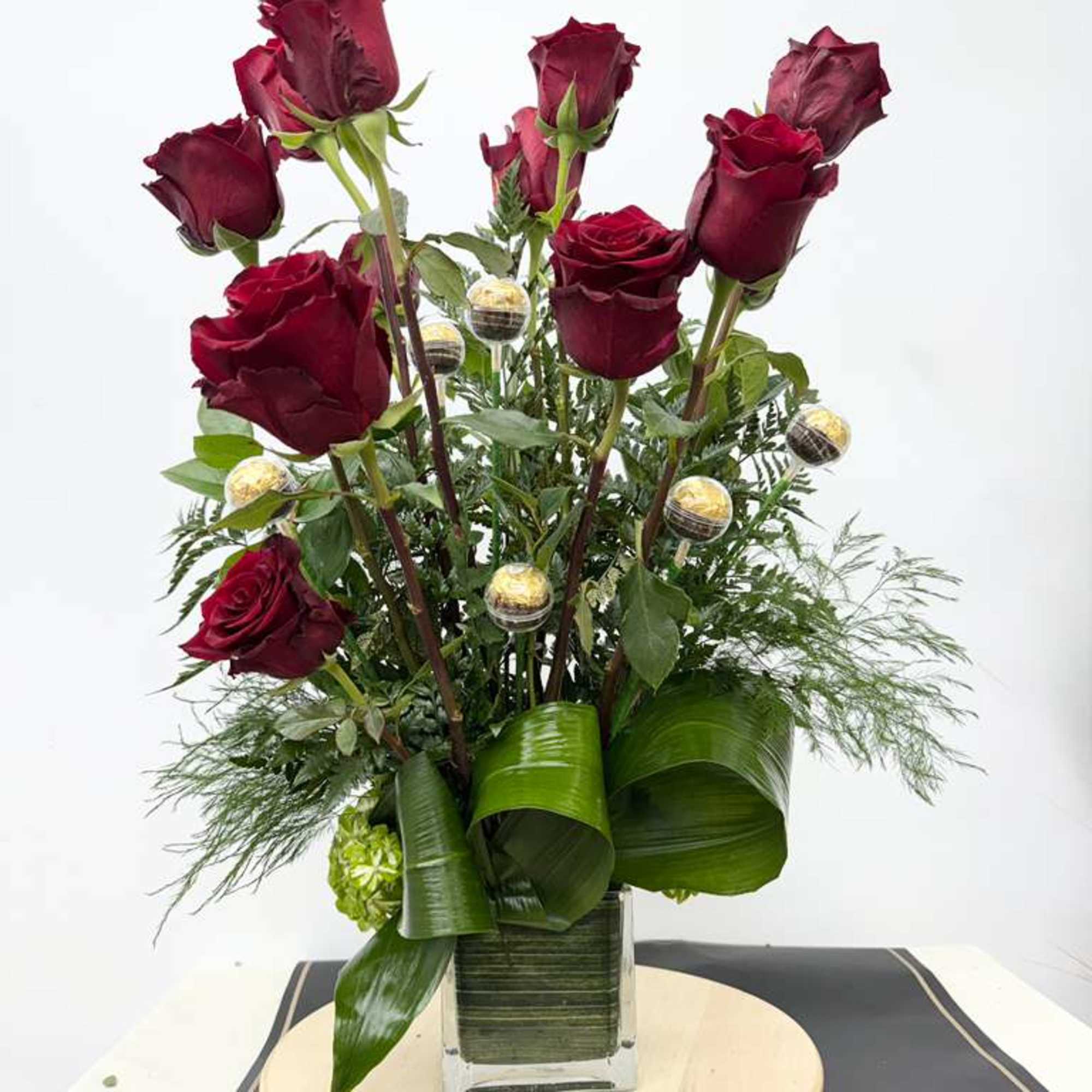 Tall arrangement of deep red roses in a glass vase
