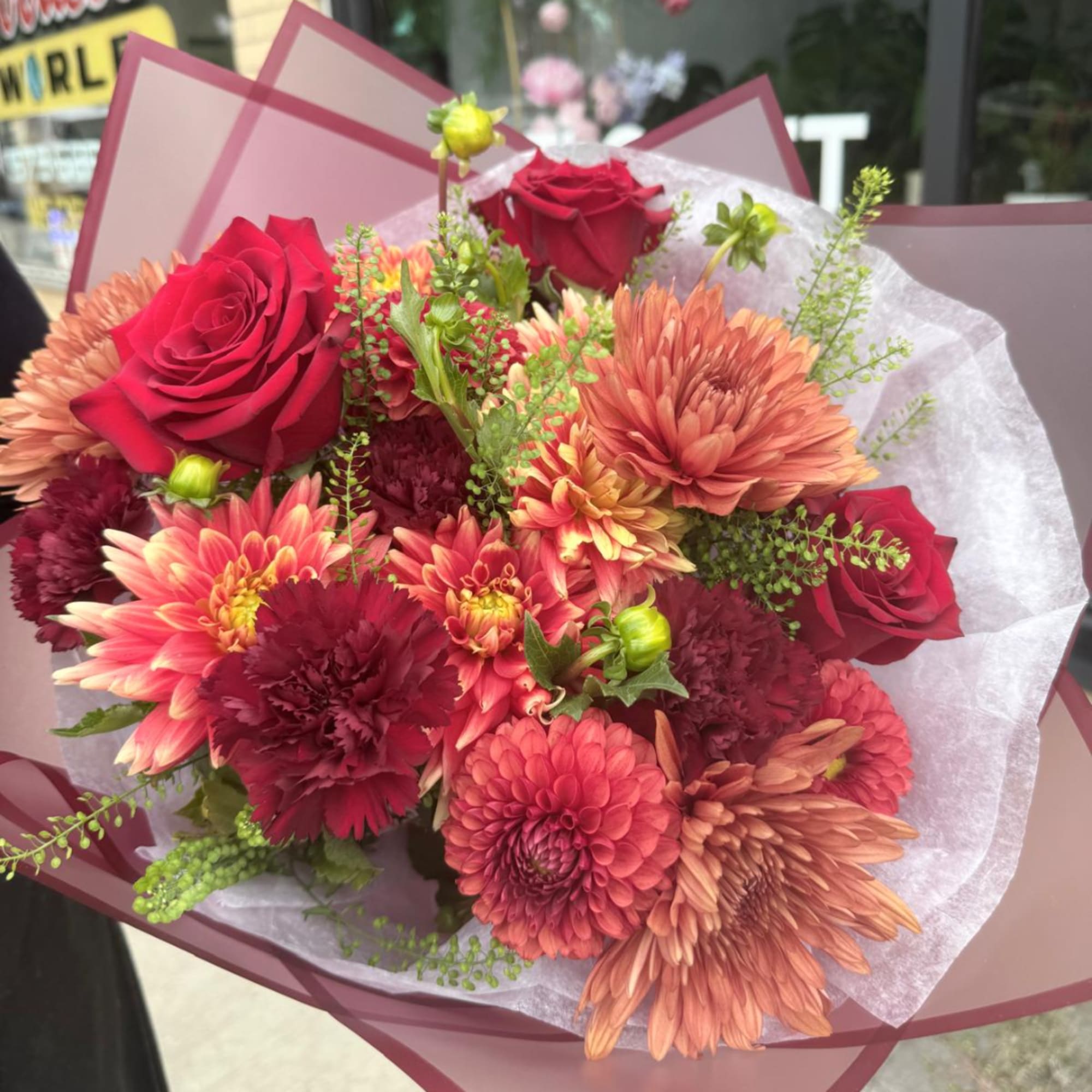 Bouquet of red roses and orange chrysanthemums wrapped in pink paper, photo 2 of 4
