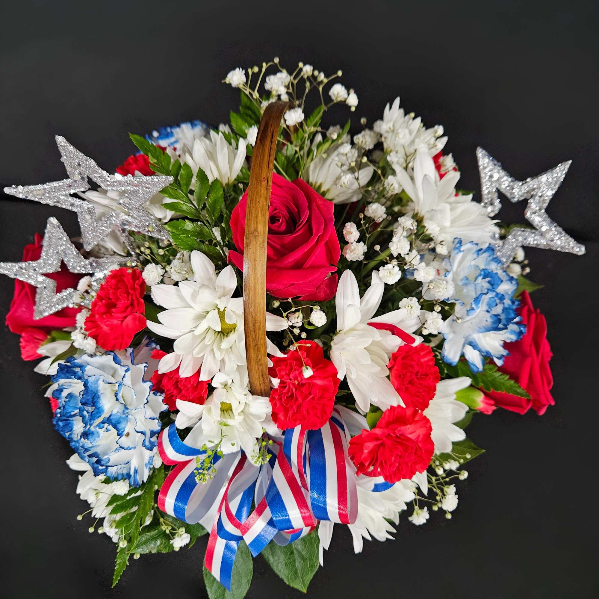 Round floral basket with red, white, and blue flowers and silver stars