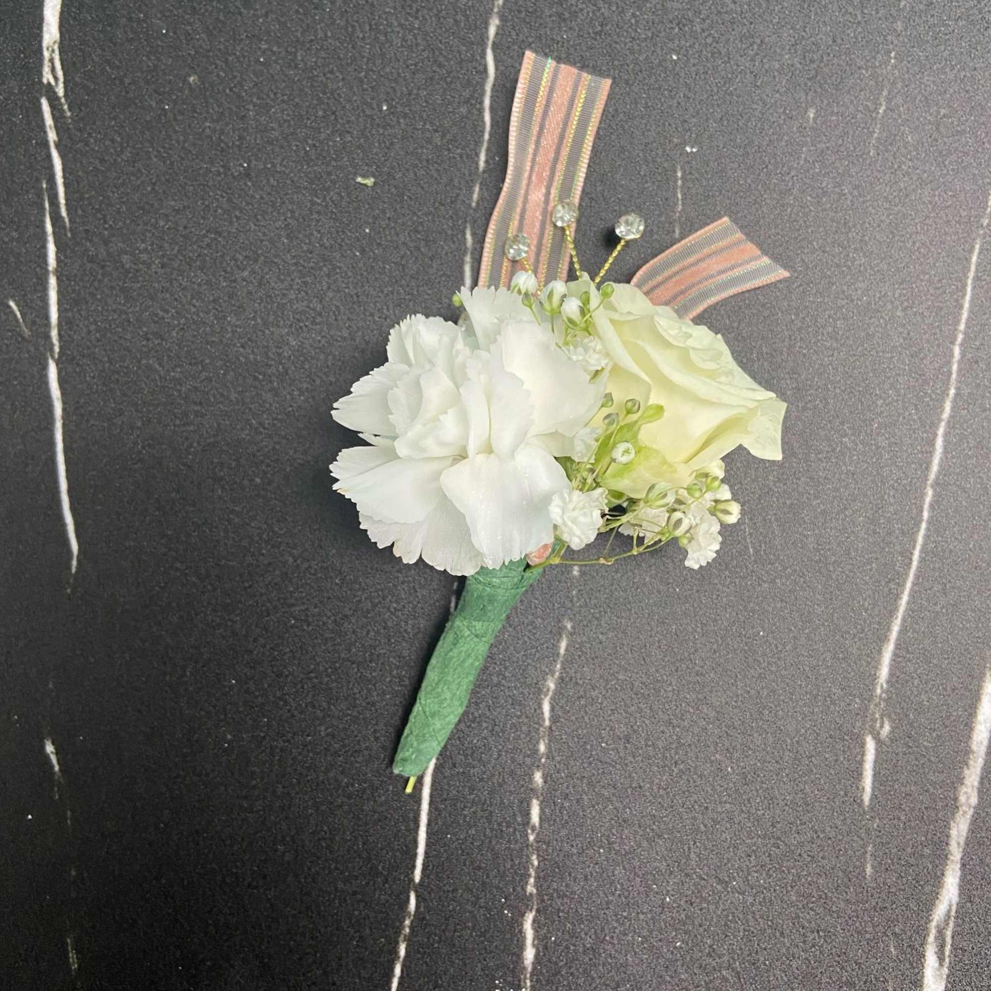 White boutonniere with ribbon accents