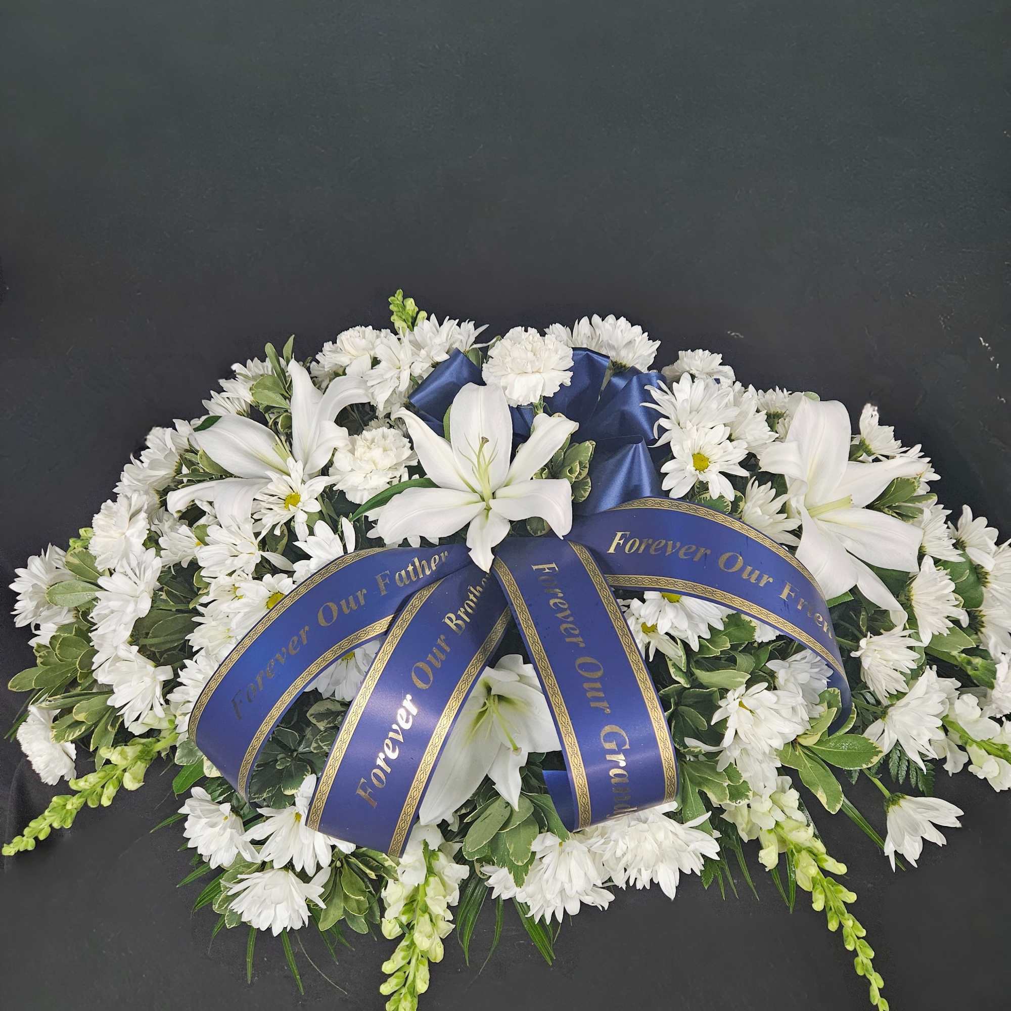 A bed of beautiful greenery is covered with white daisy poms and, photo 2 of 2