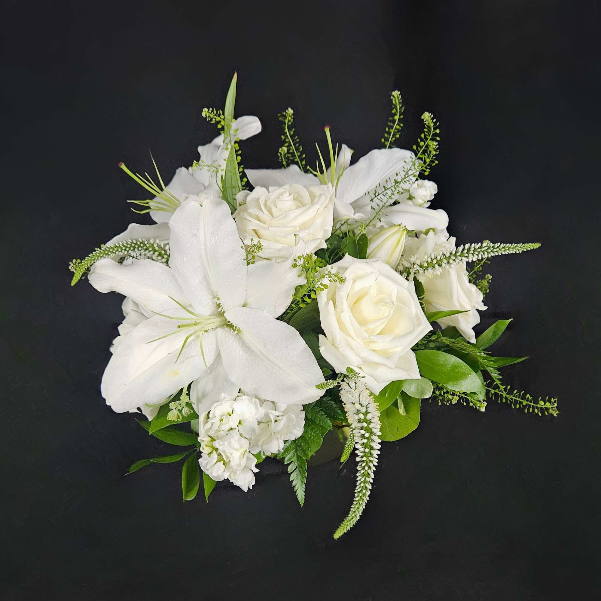 This arrangement includes white roses, white lilies, white stock, and dusty miller., photo 4 of 4