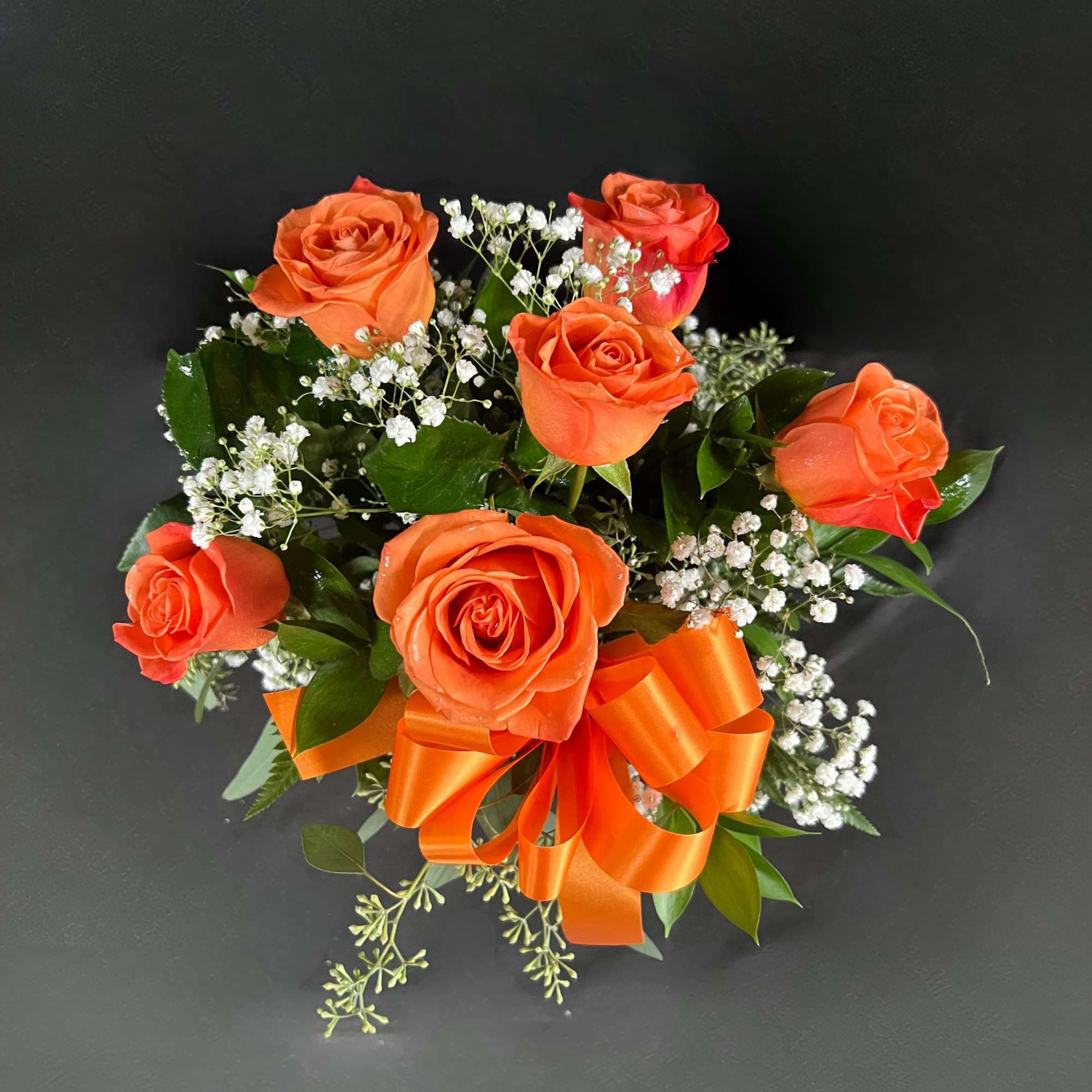Orange rose bouquet with white baby's breath and an orange ribbon