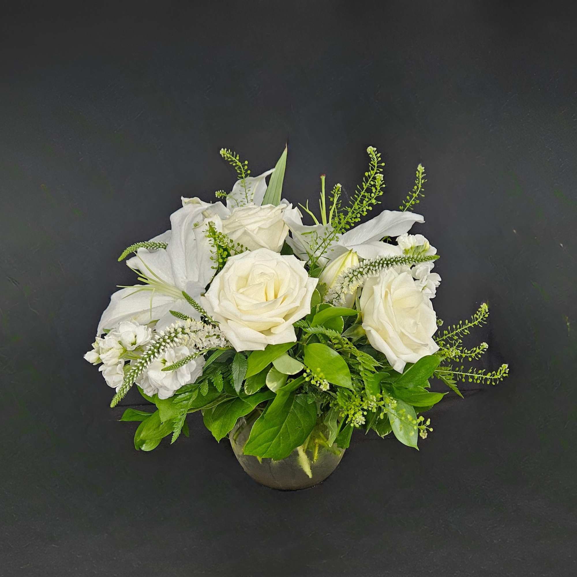 This arrangement includes white roses, white lilies, white stock, and dusty miller., photo 2 of 4