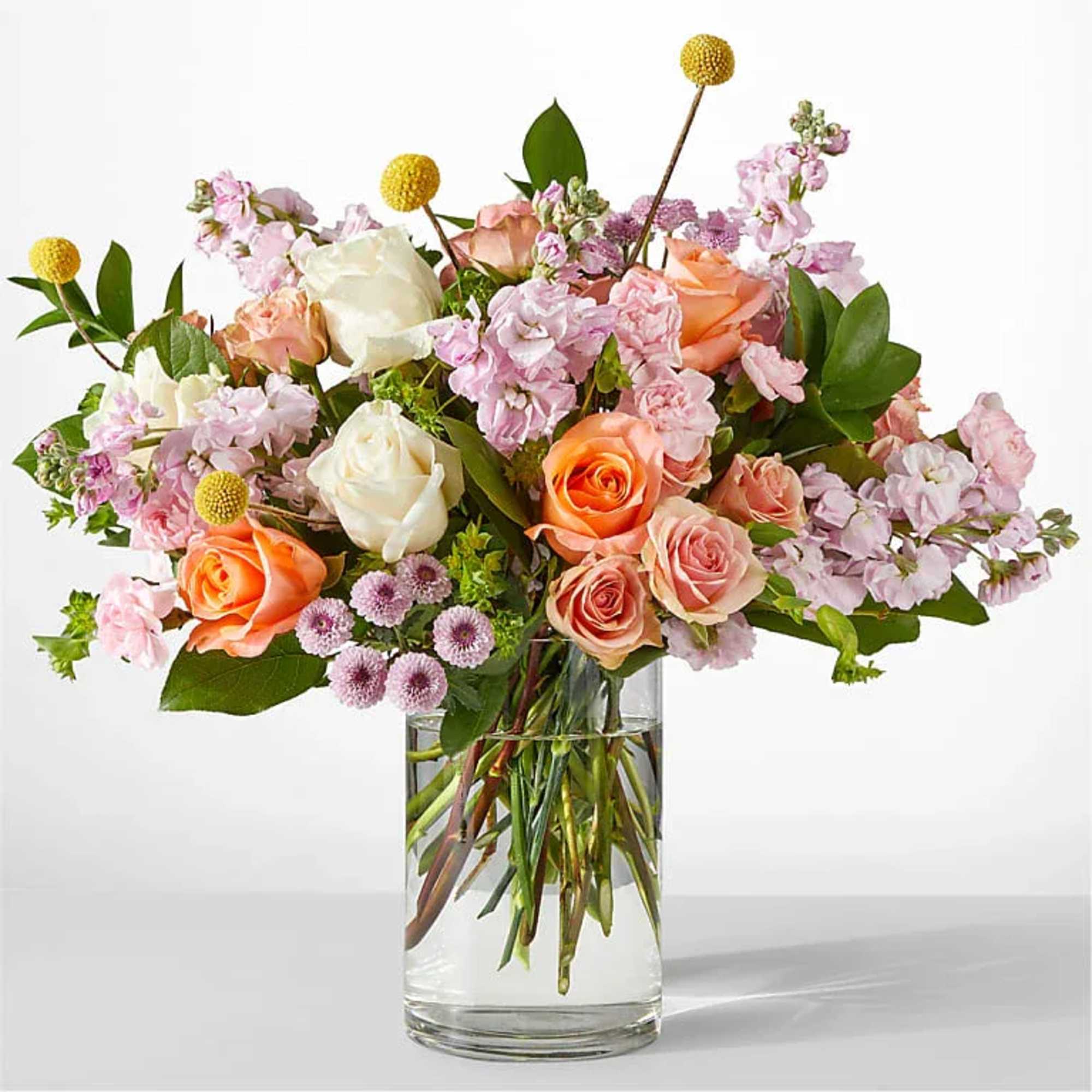 Mixed pink and peach roses in a clear glass vase