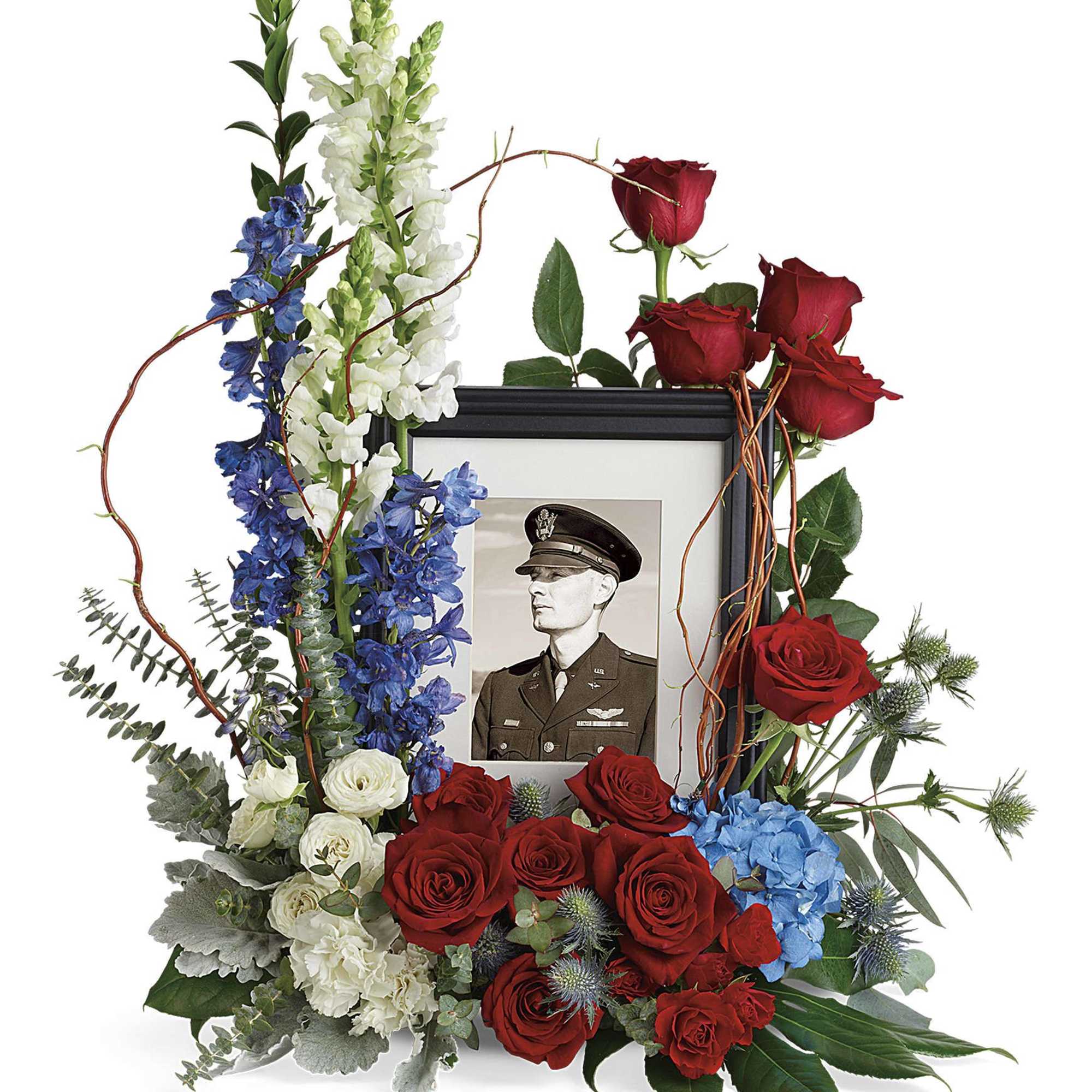 Floral memorial frame with red roses, blue flowers, and a portrait photo