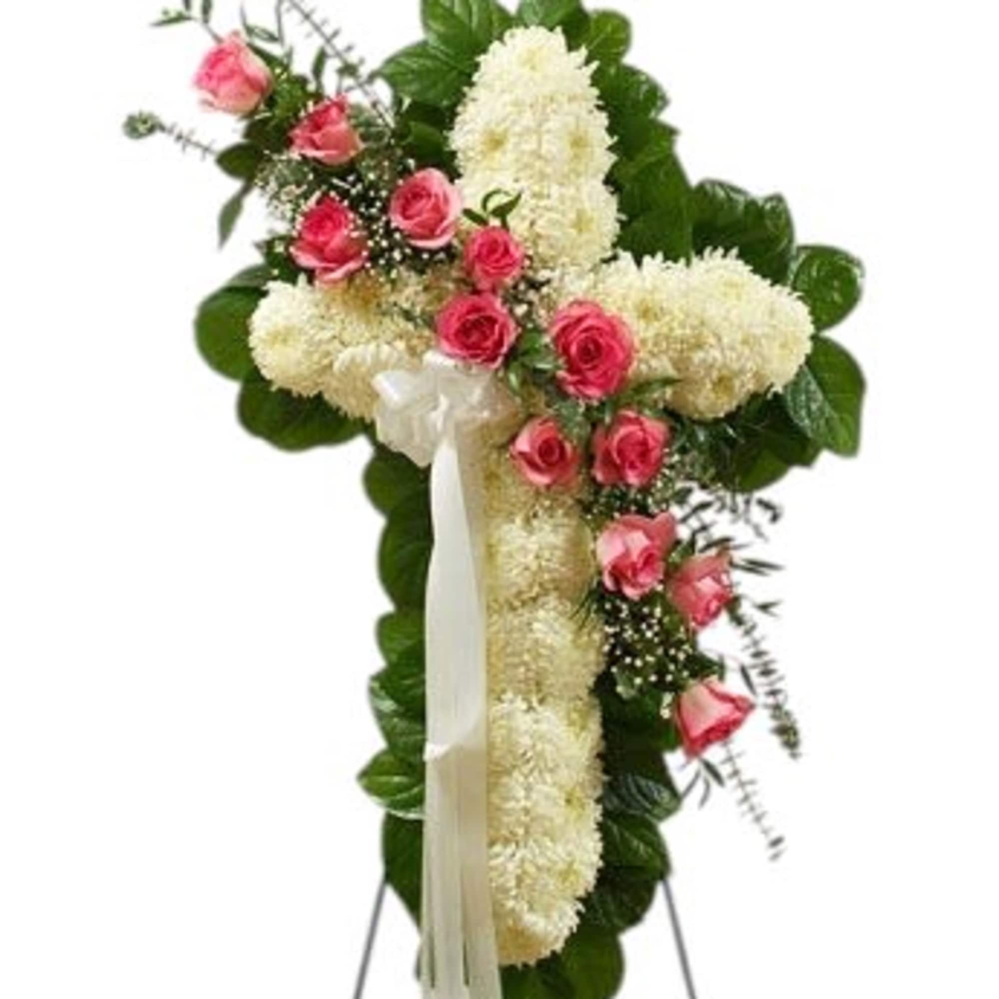 Pink roses and white flowers arranged in a cross-shaped standing spray